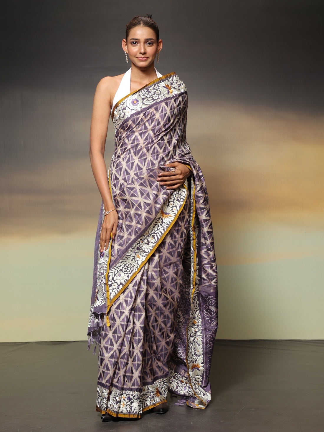 The stunning piece of art features tie-dyed ikkat in a captivating lavender shade with intricate Parsi Gara hand embroidery work