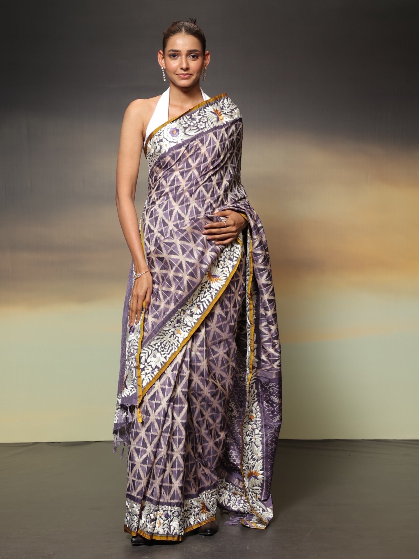 The stunning piece of art features tie-dyed ikkat in a captivating lavender shade with intricate Parsi Gara hand embroidery work