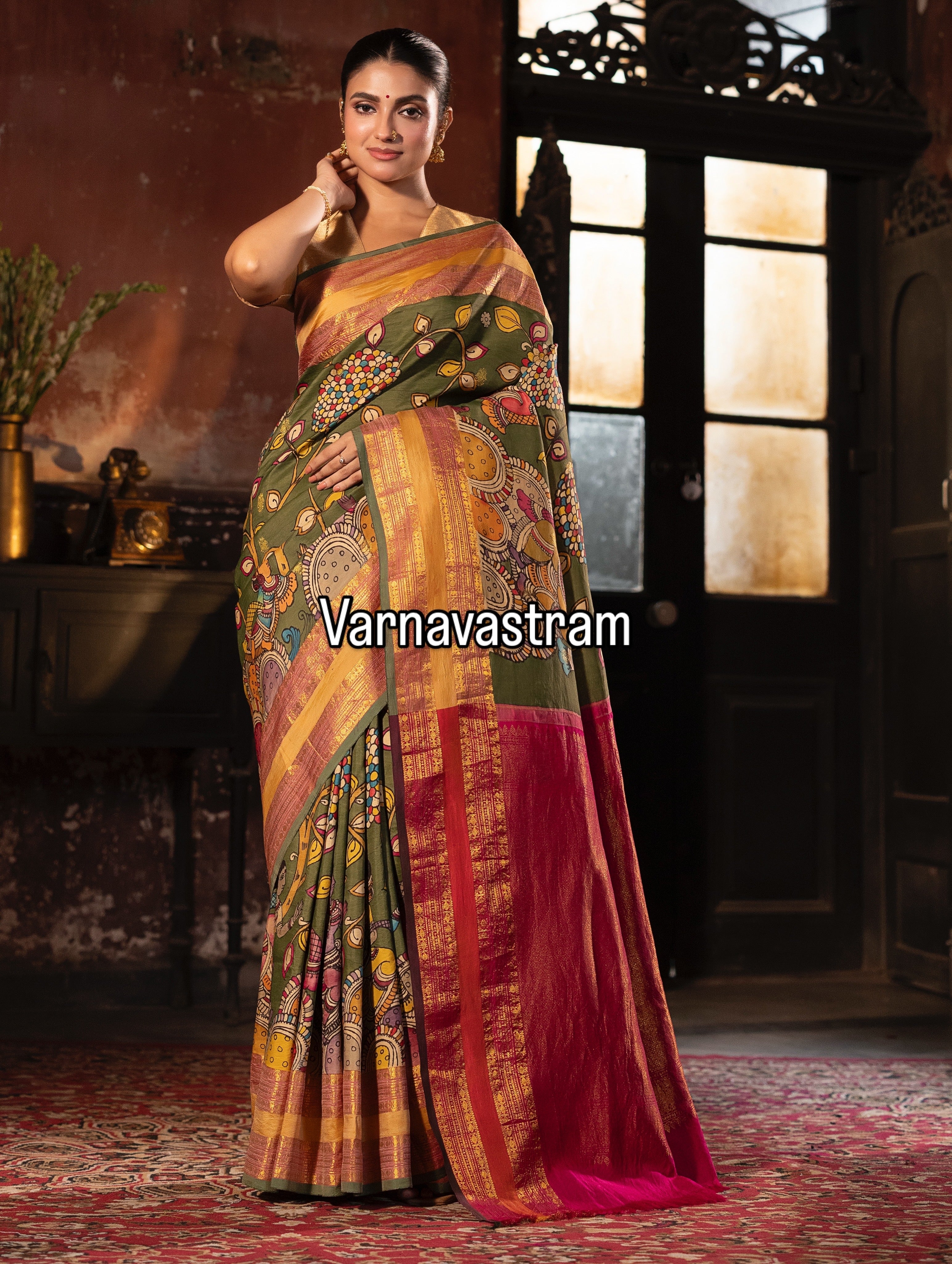 A beautiful and traditional korvai kanchivaram silk saree adorned with forest green base , dancing apsaras and floral creepers Handdrawn handpainted penkalamkari