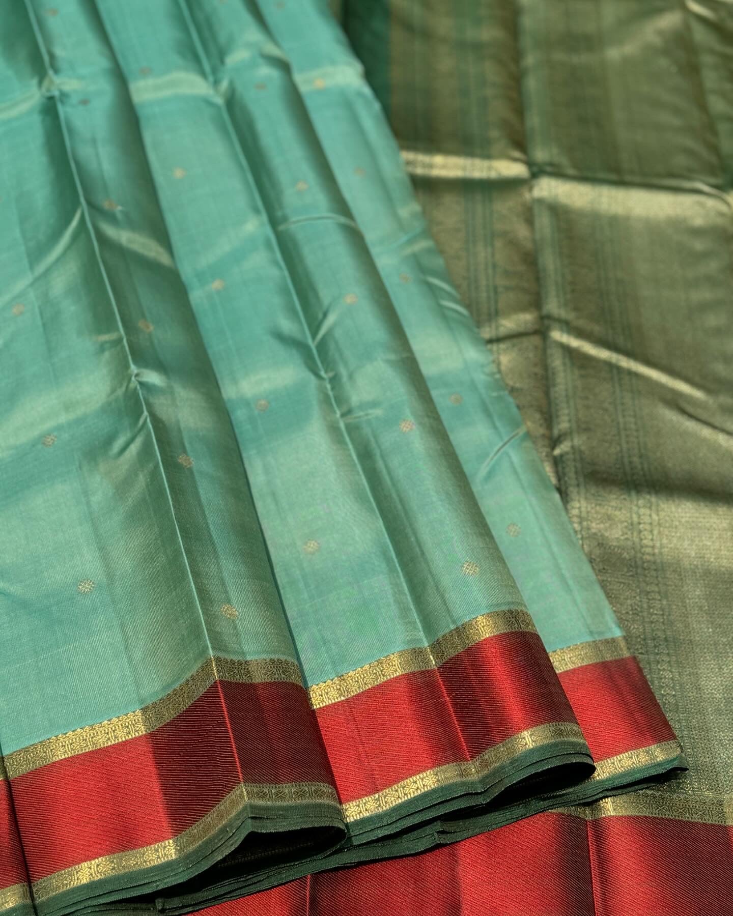A gorgeous cyan green with red threadwork and zari border kanchivaram silk SAREE