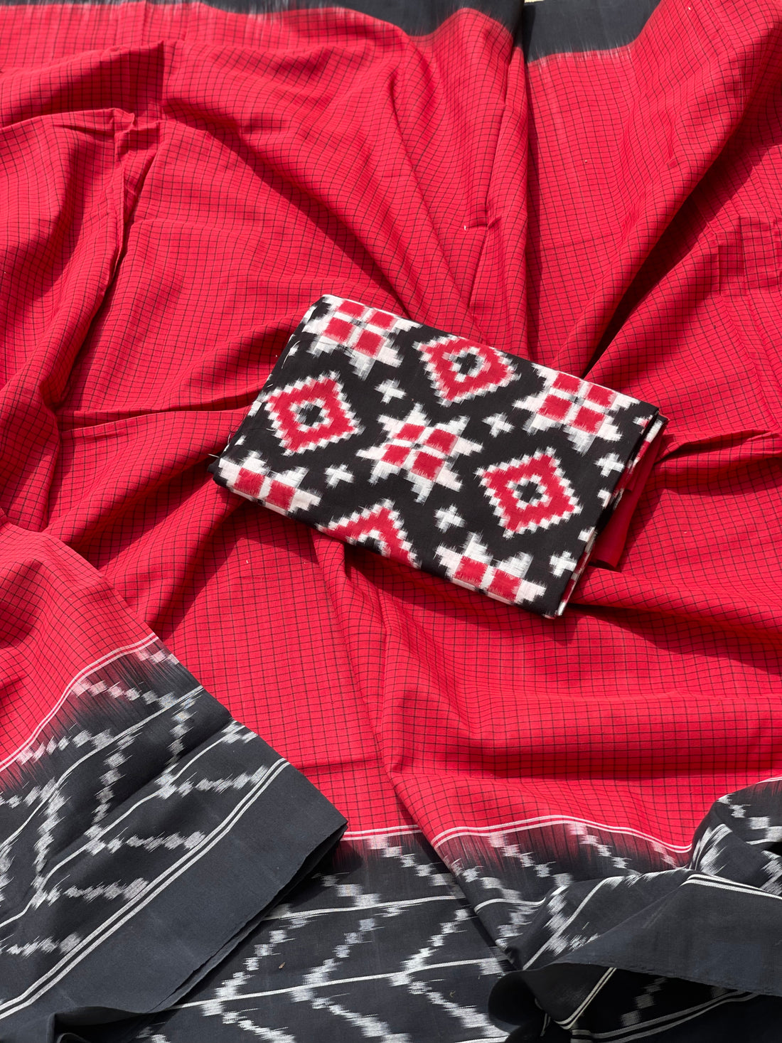 A Red checkered weft ikkat cotton Saree with chevron black border