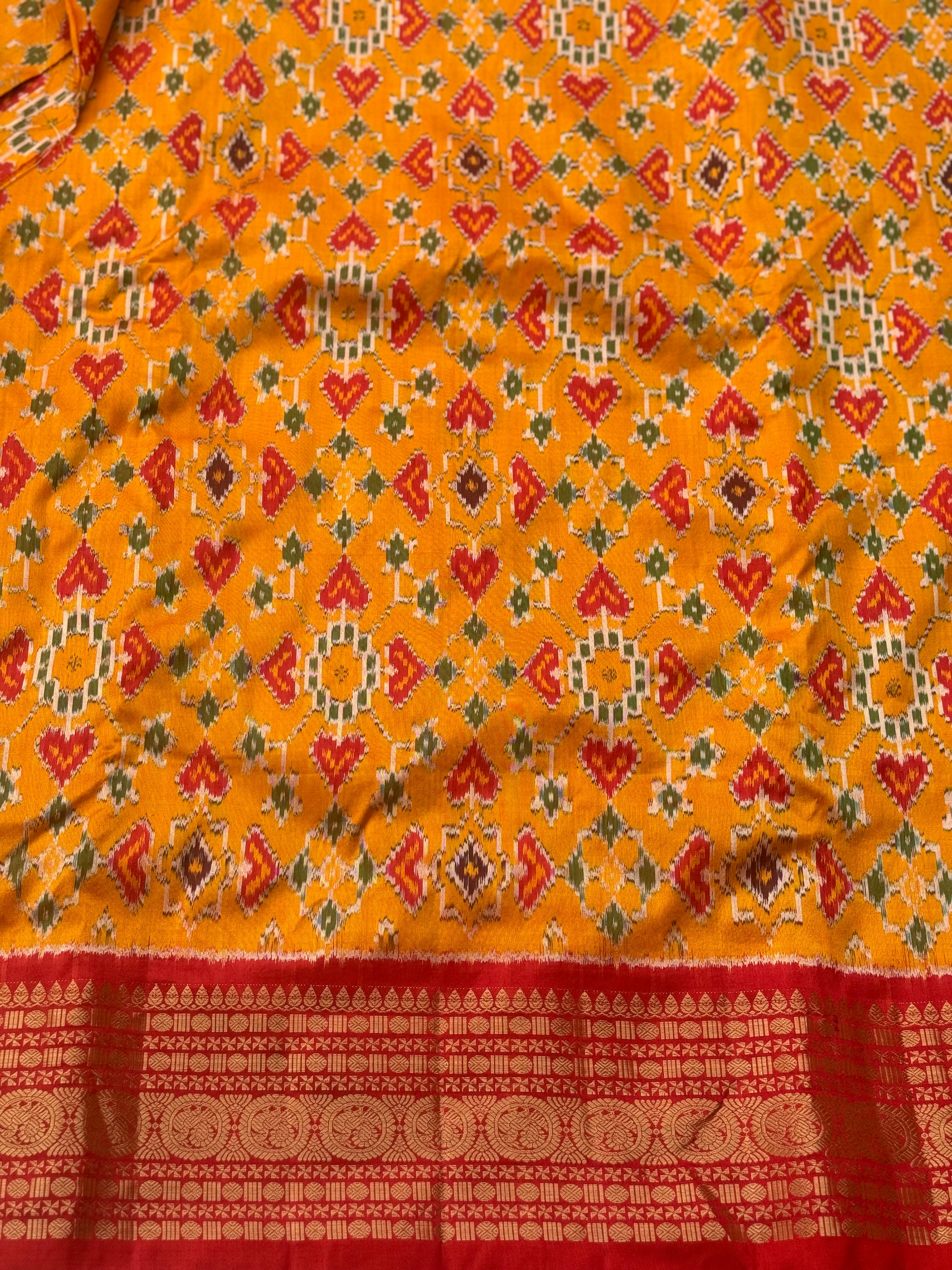 Yellowish orange with red kanchi jacquard weave zari border patola inspired navratan ikkat design on pure mulberry silk fabric
