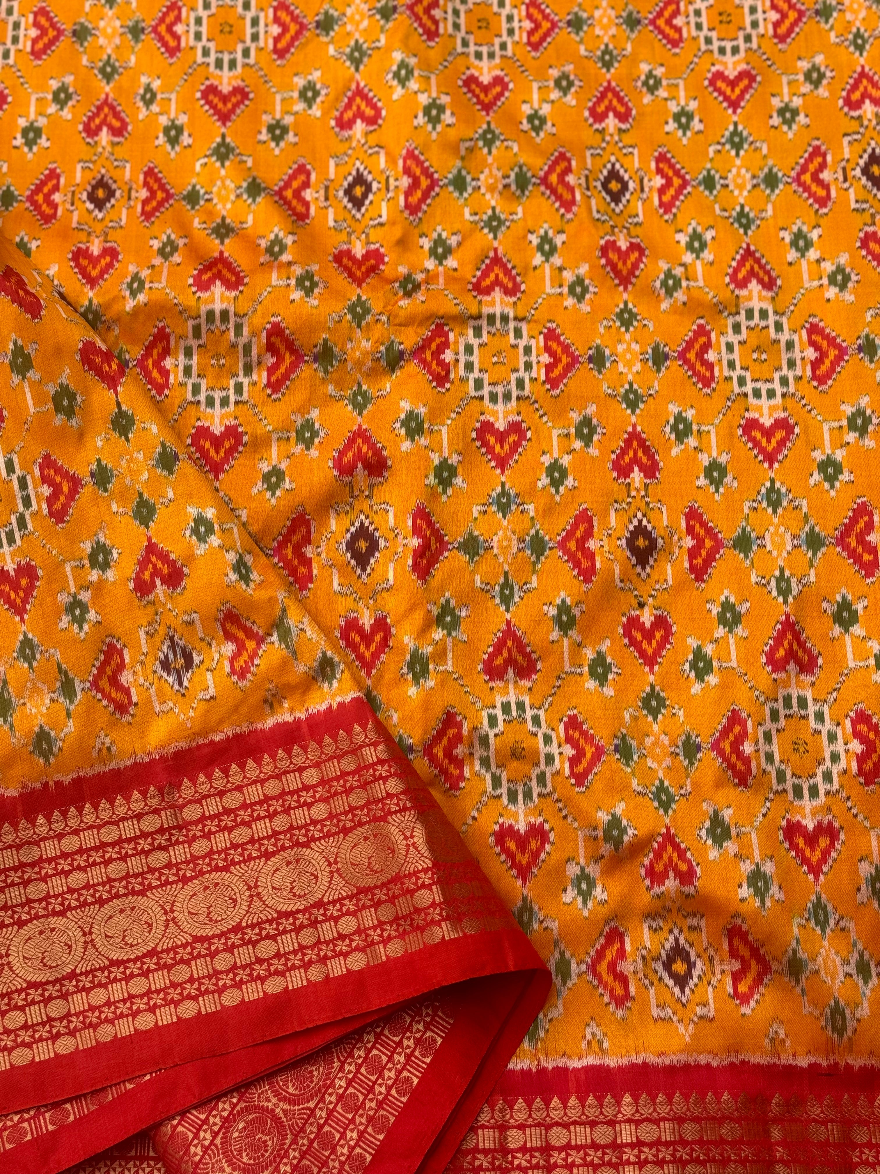 Yellowish orange with red kanchi jacquard weave zari border patola inspired navratan ikkat design on pure mulberry silk fabric