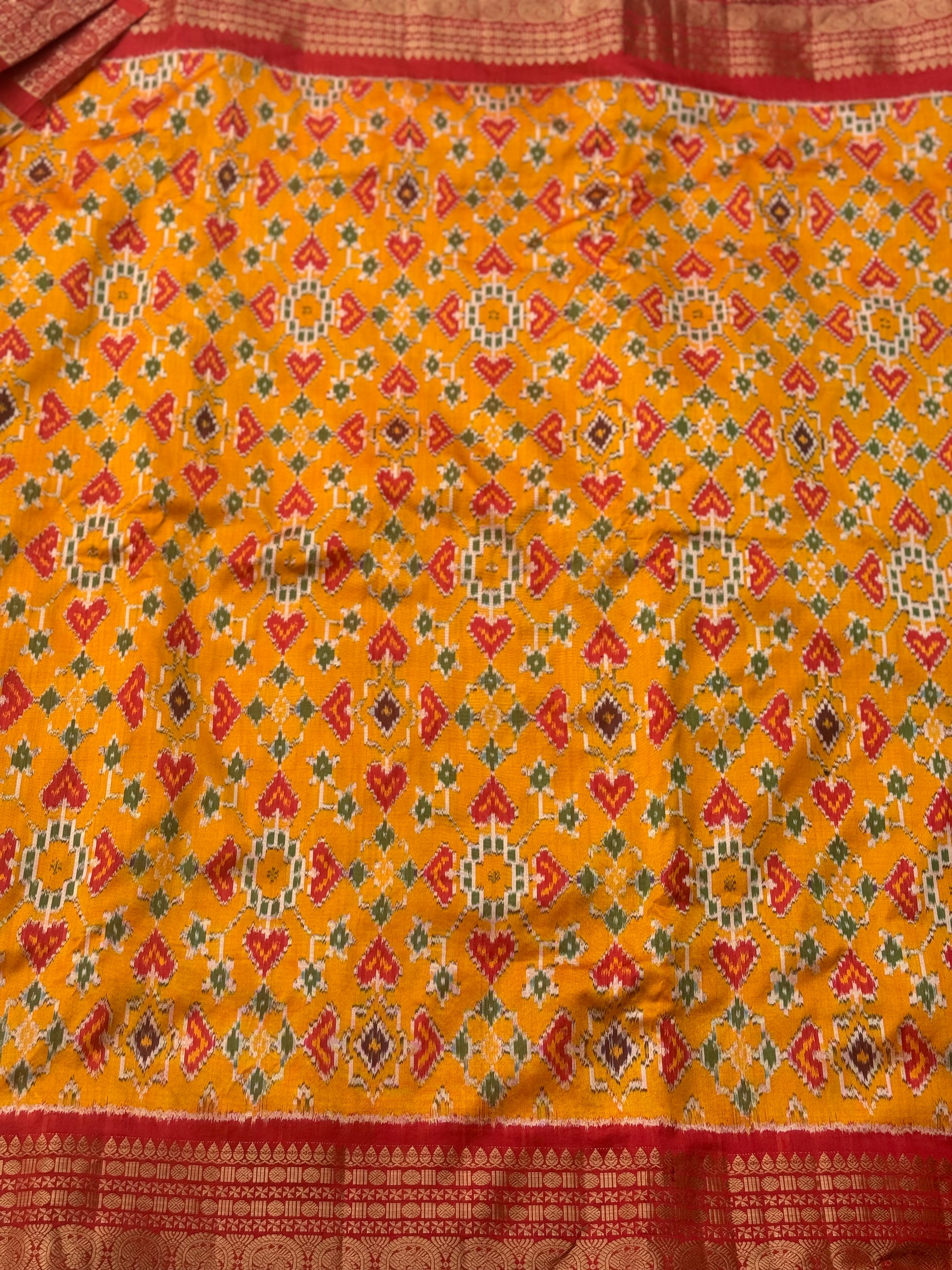 Yellowish orange with red kanchi jacquard weave zari border patola inspired navratan ikkat design on pure mulberry silk fabric