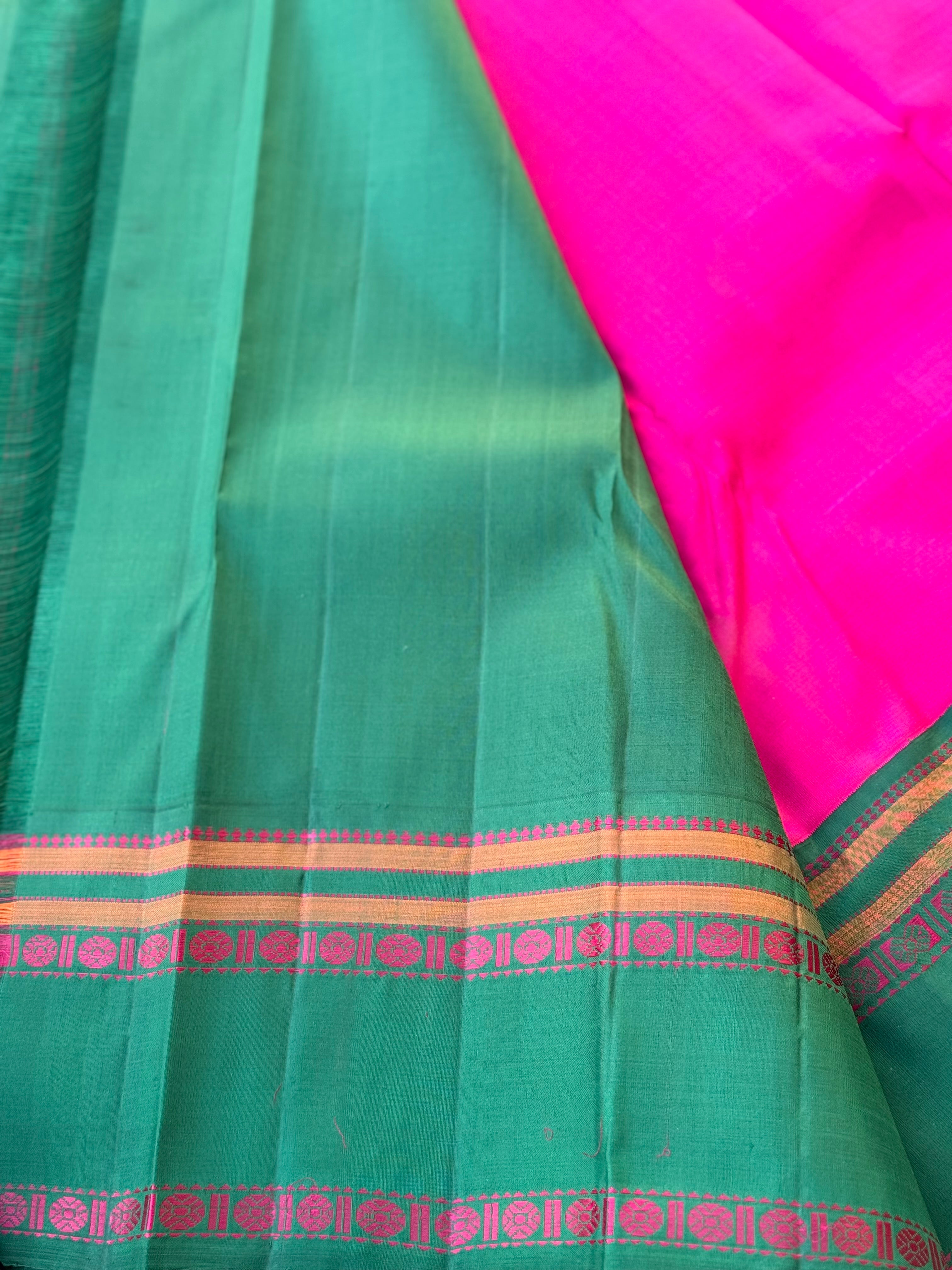 A subtle handwoven pattu rose pink shade with green Threadwork Kai korvai kanchivaram silk saree