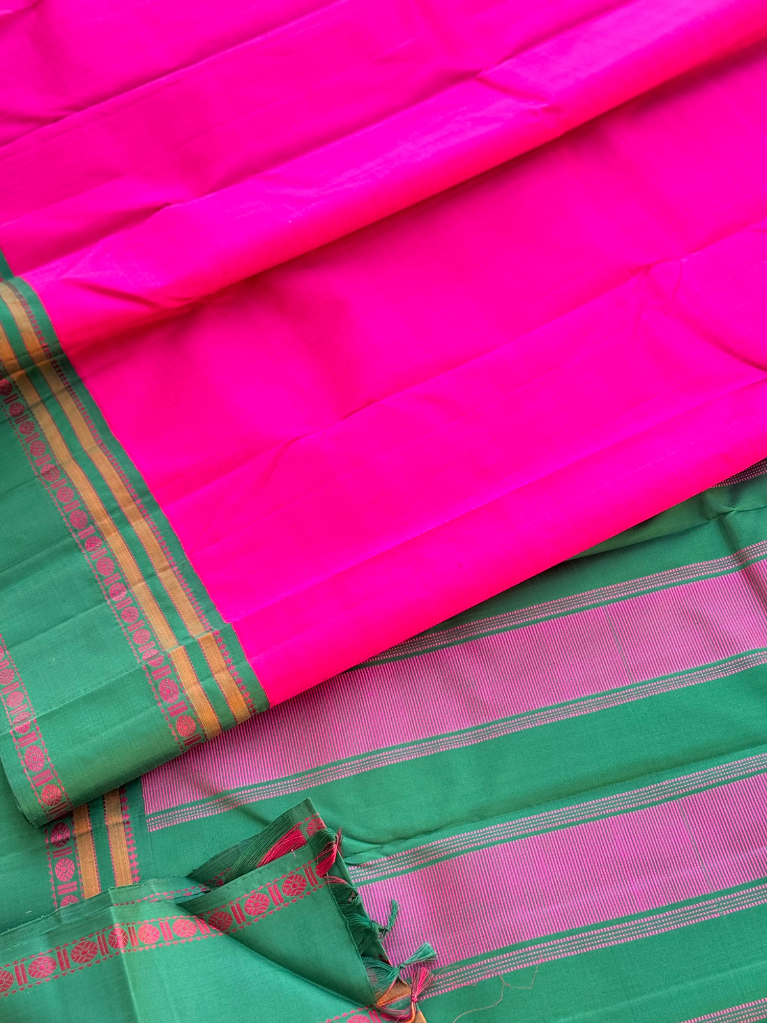 A subtle handwoven pattu rose pink shade with green Threadwork Kai korvai kanchivaram silk saree