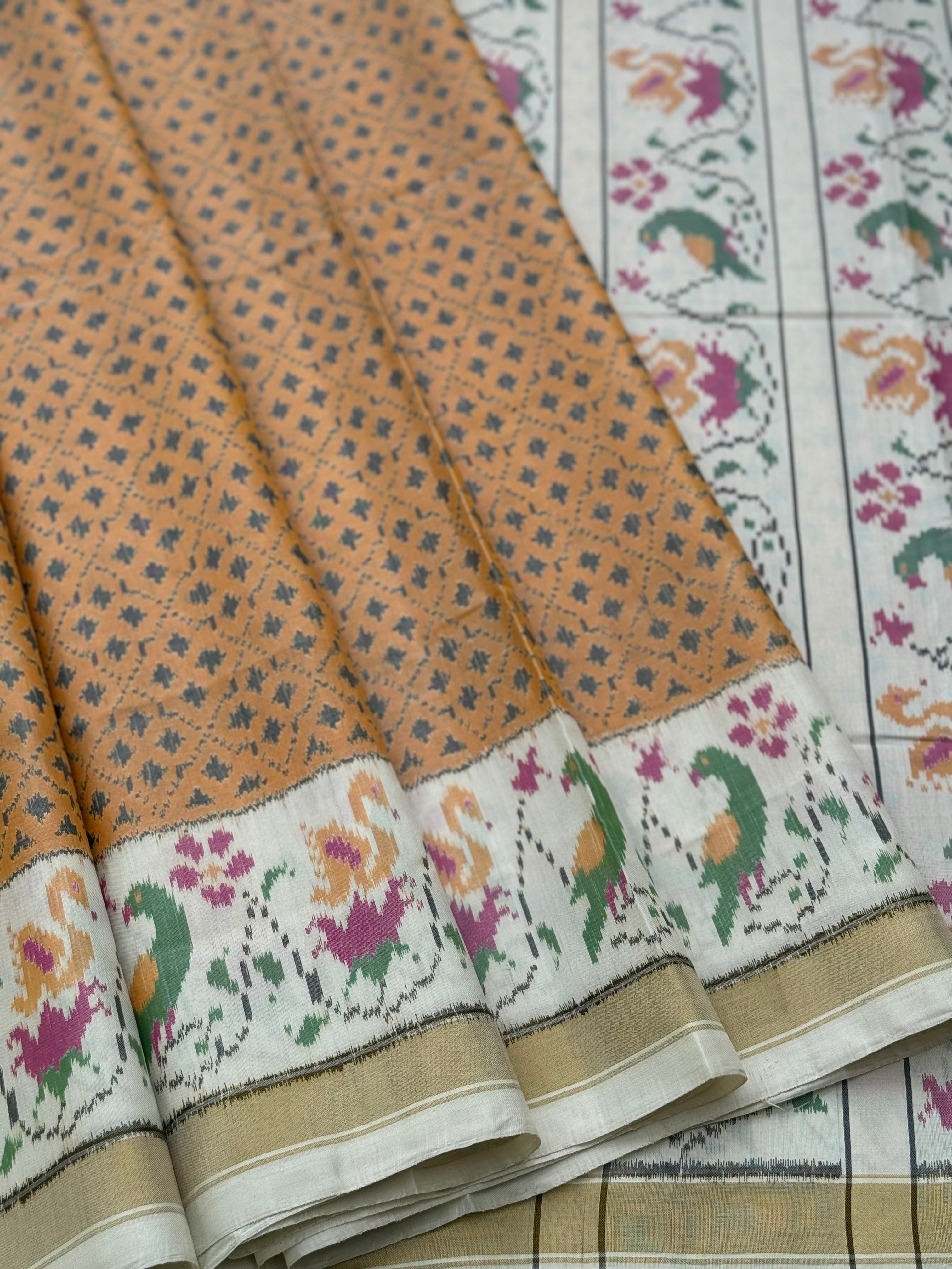 A gorgeous muted gold with offwhite single ikkat patola silk SAREE