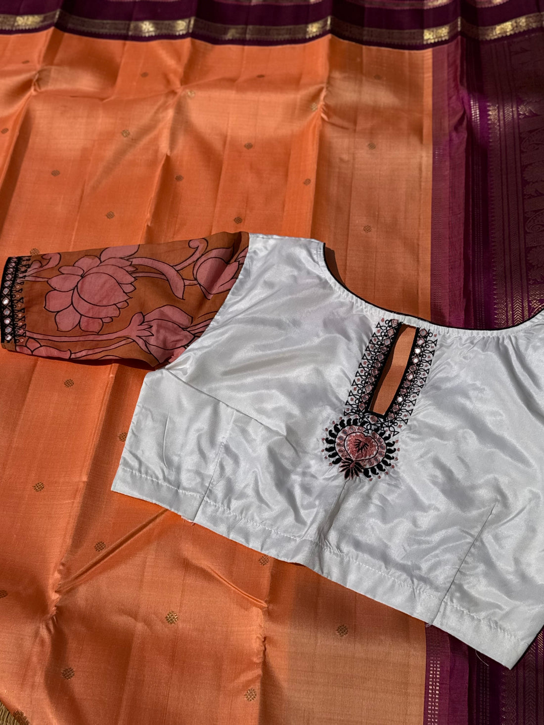 The contemporary style on peach orange with ivory white silk penkalamkari blouse