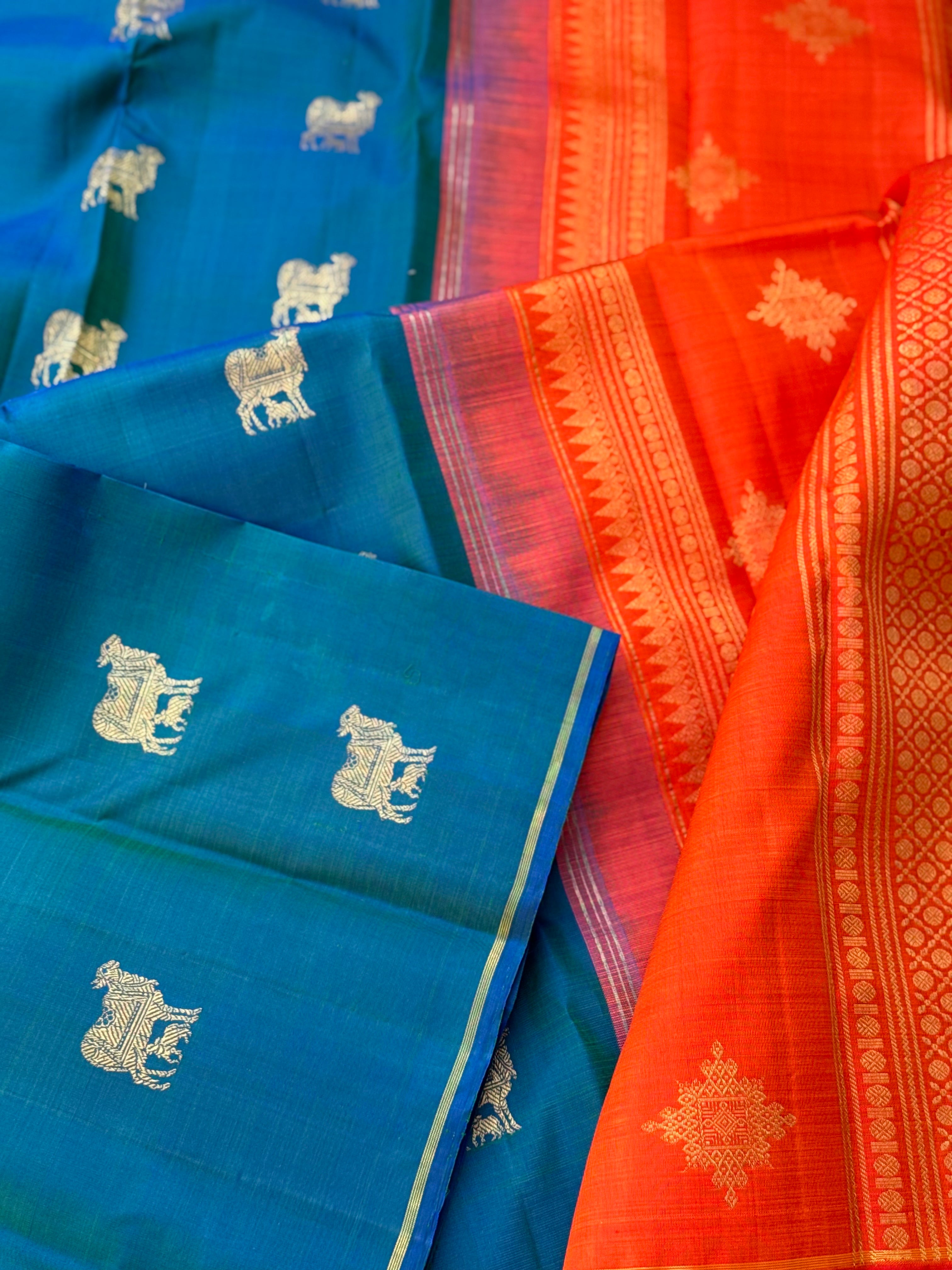 A stunner peacock blue shade with orange borderless kanchivaram silk saree