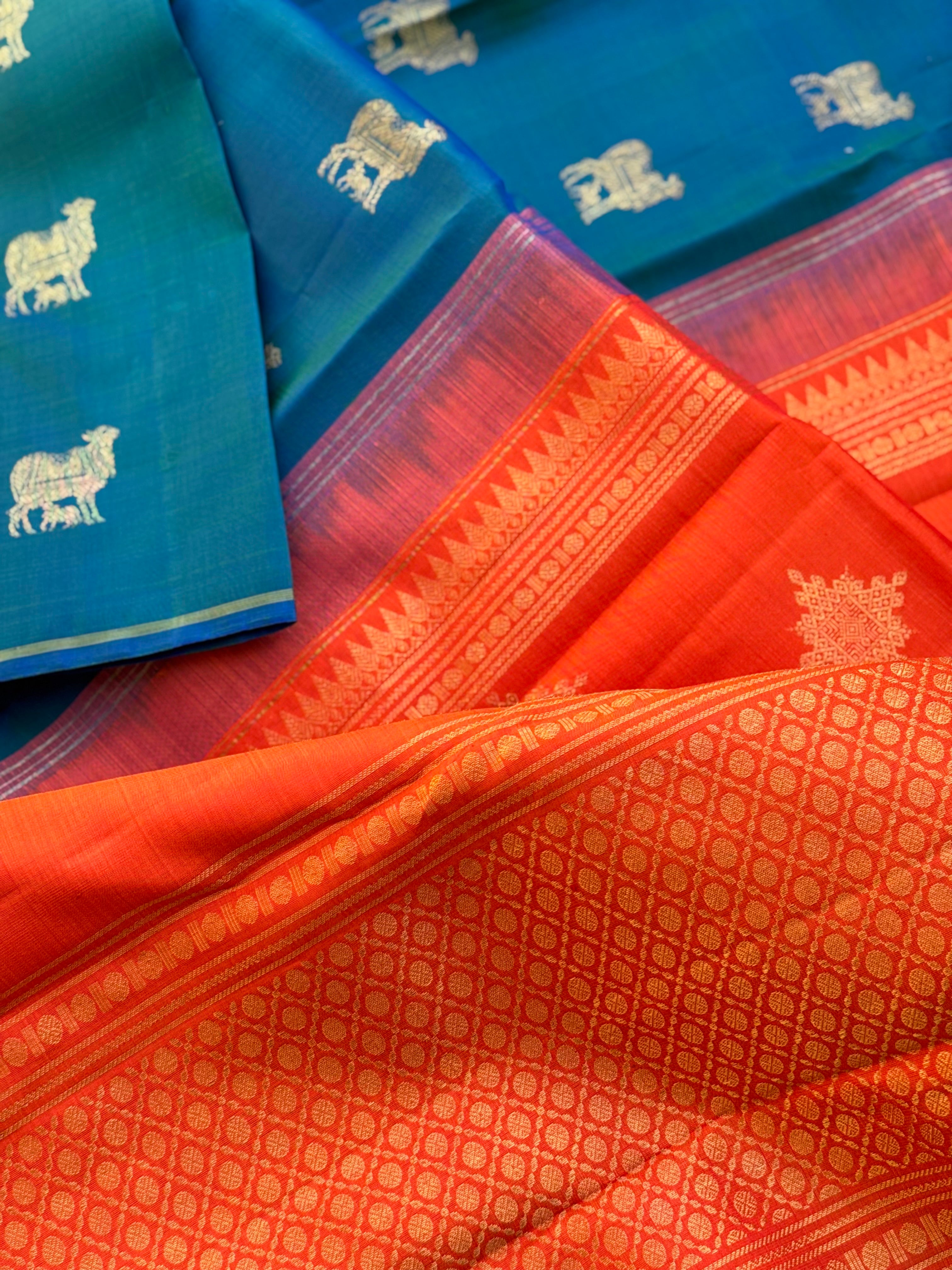 A stunner peacock blue shade with orange borderless kanchivaram silk saree