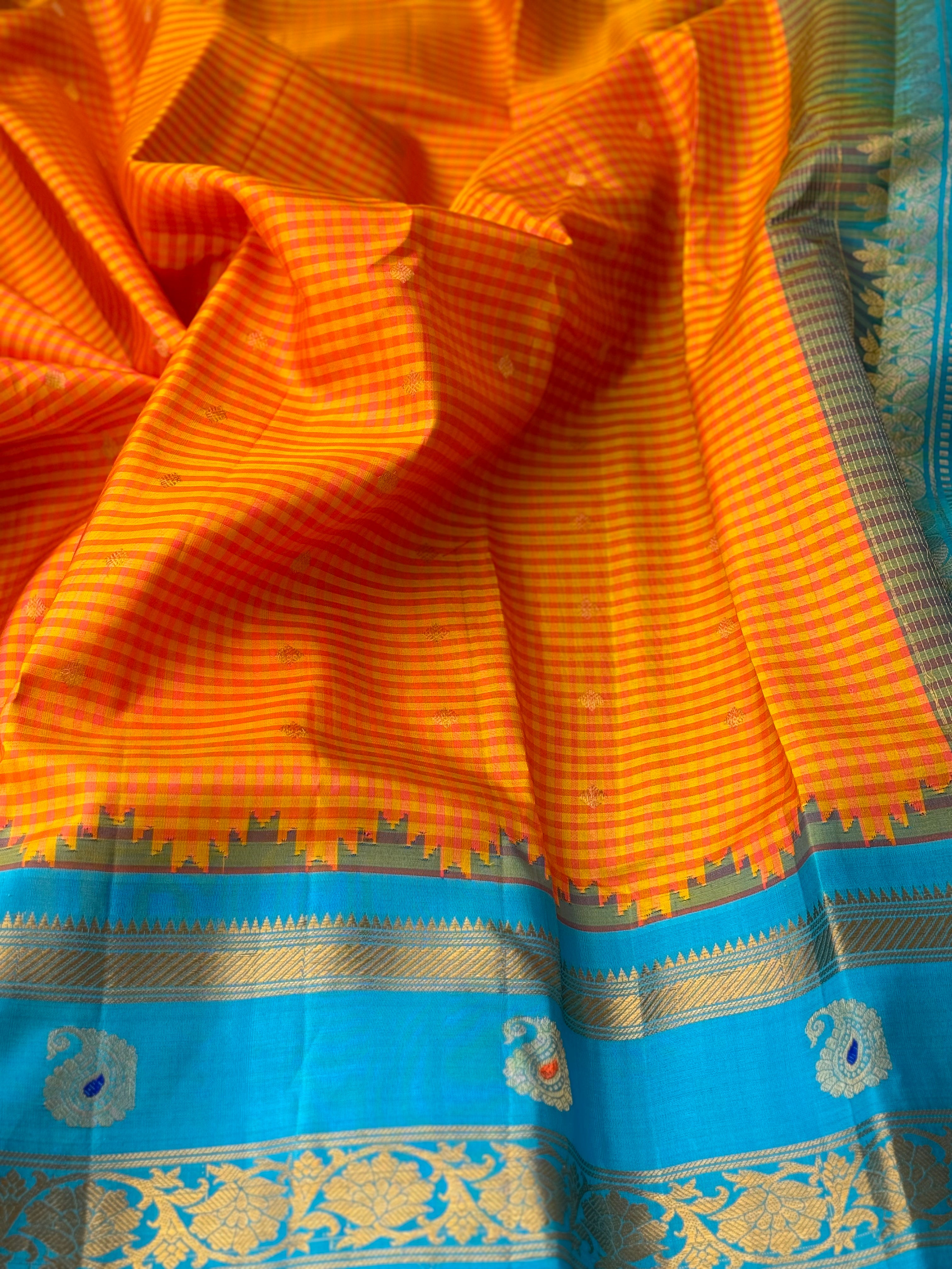 An Elegant sunset Orange with blue Gadwal silk saree with meenakari border