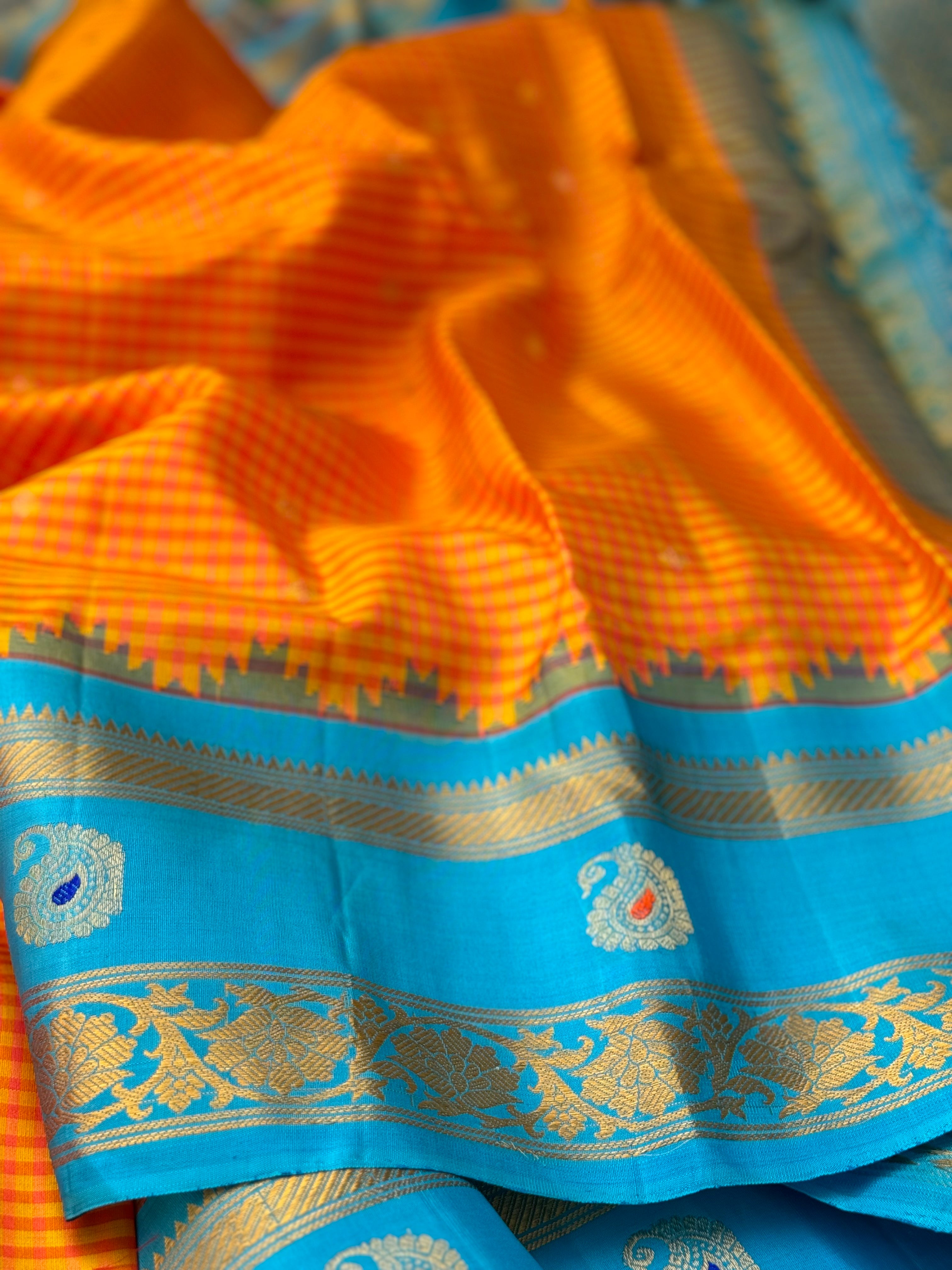 An Elegant sunset Orange with blue Gadwal silk saree with meenakari border