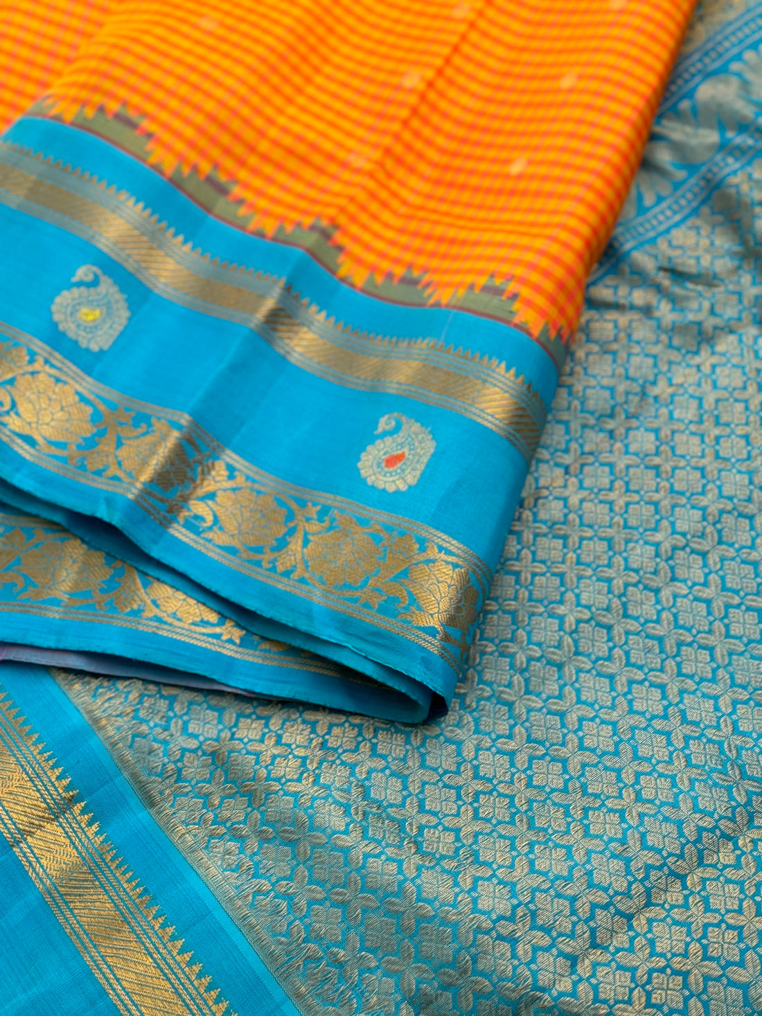 An Elegant sunset Orange with blue Gadwal silk saree with meenakari border