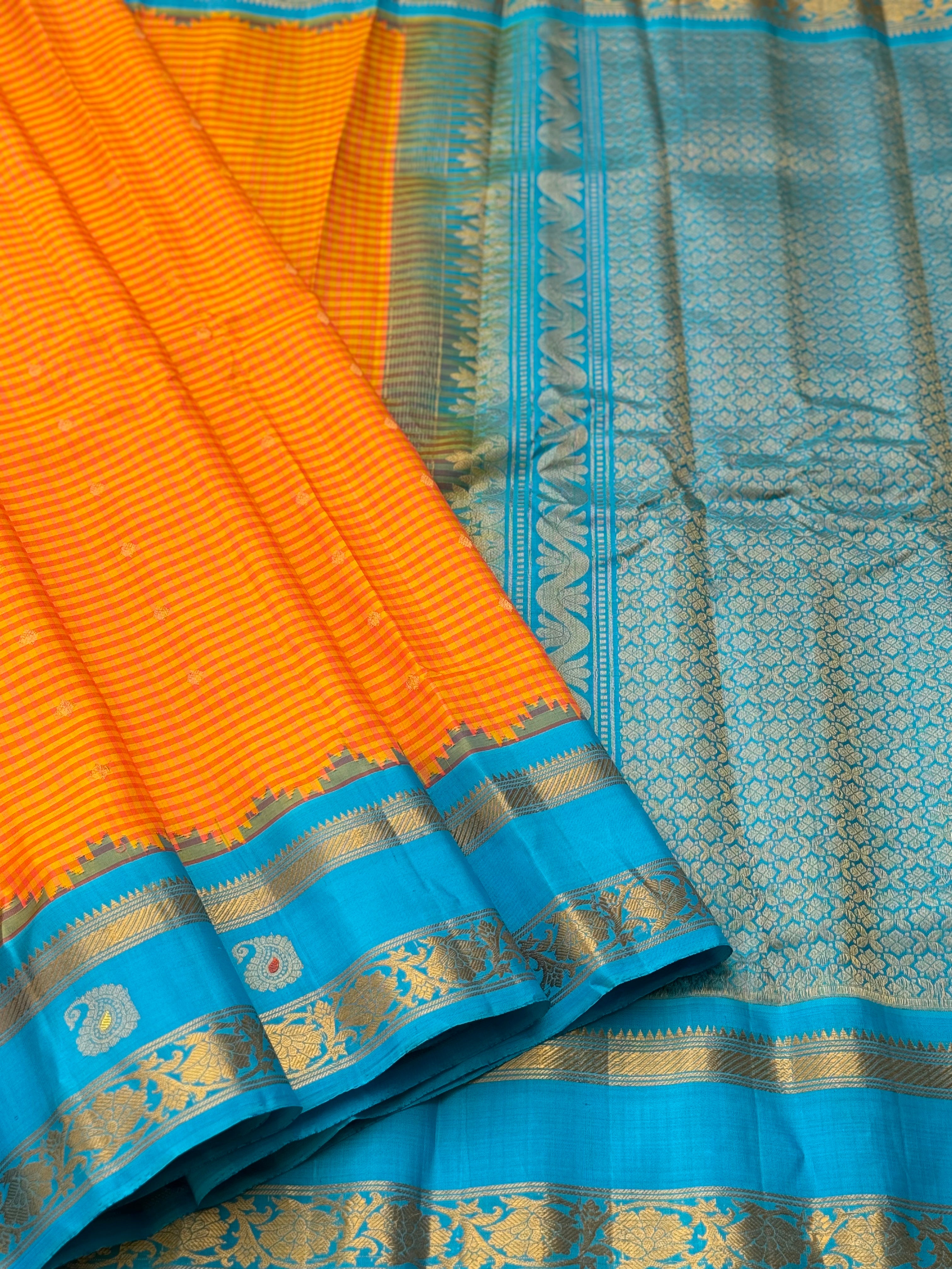 An Elegant sunset Orange with blue Gadwal silk saree with meenakari border