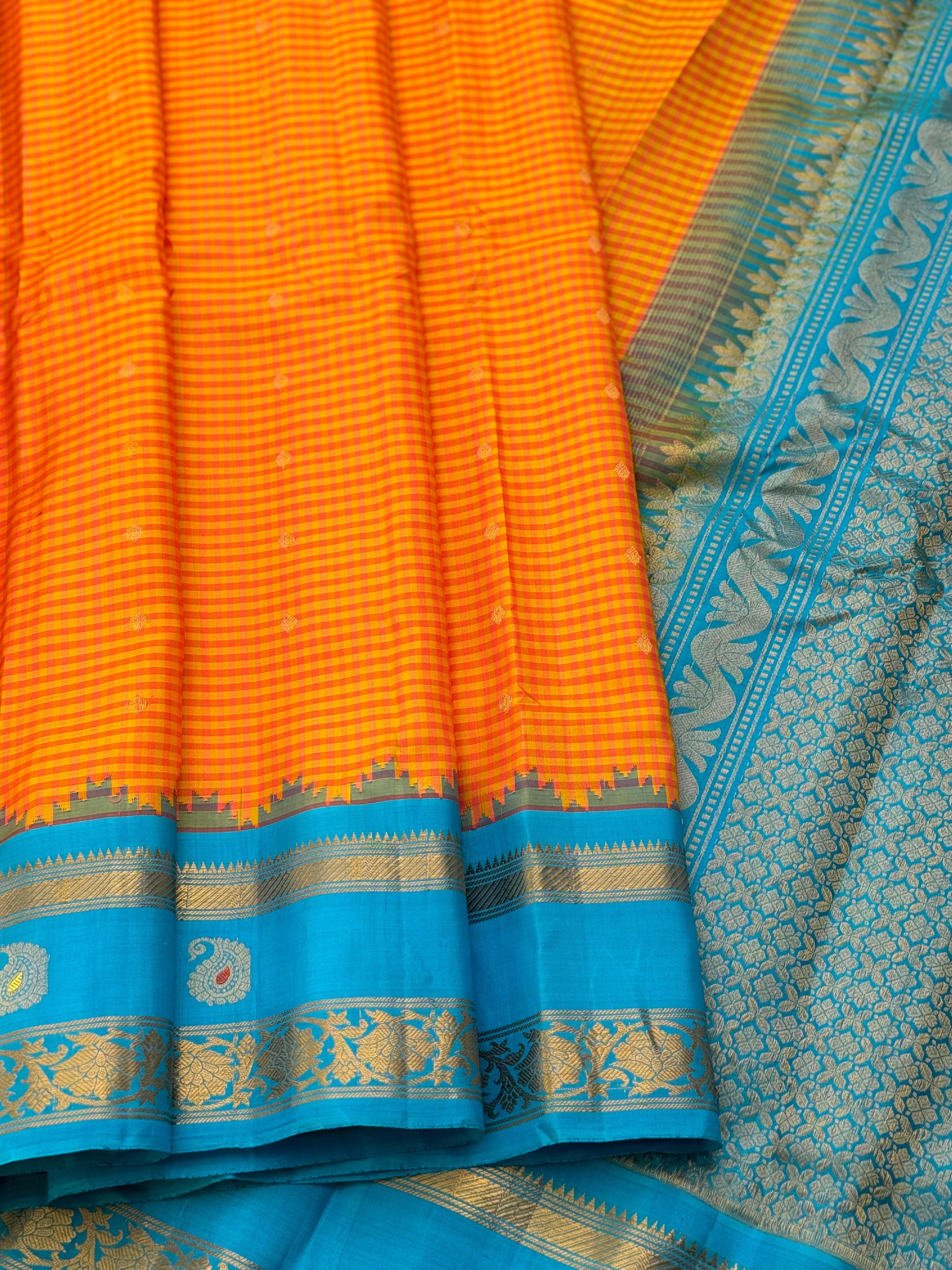 An Elegant sunset Orange with blue Gadwal silk saree with meenakari border