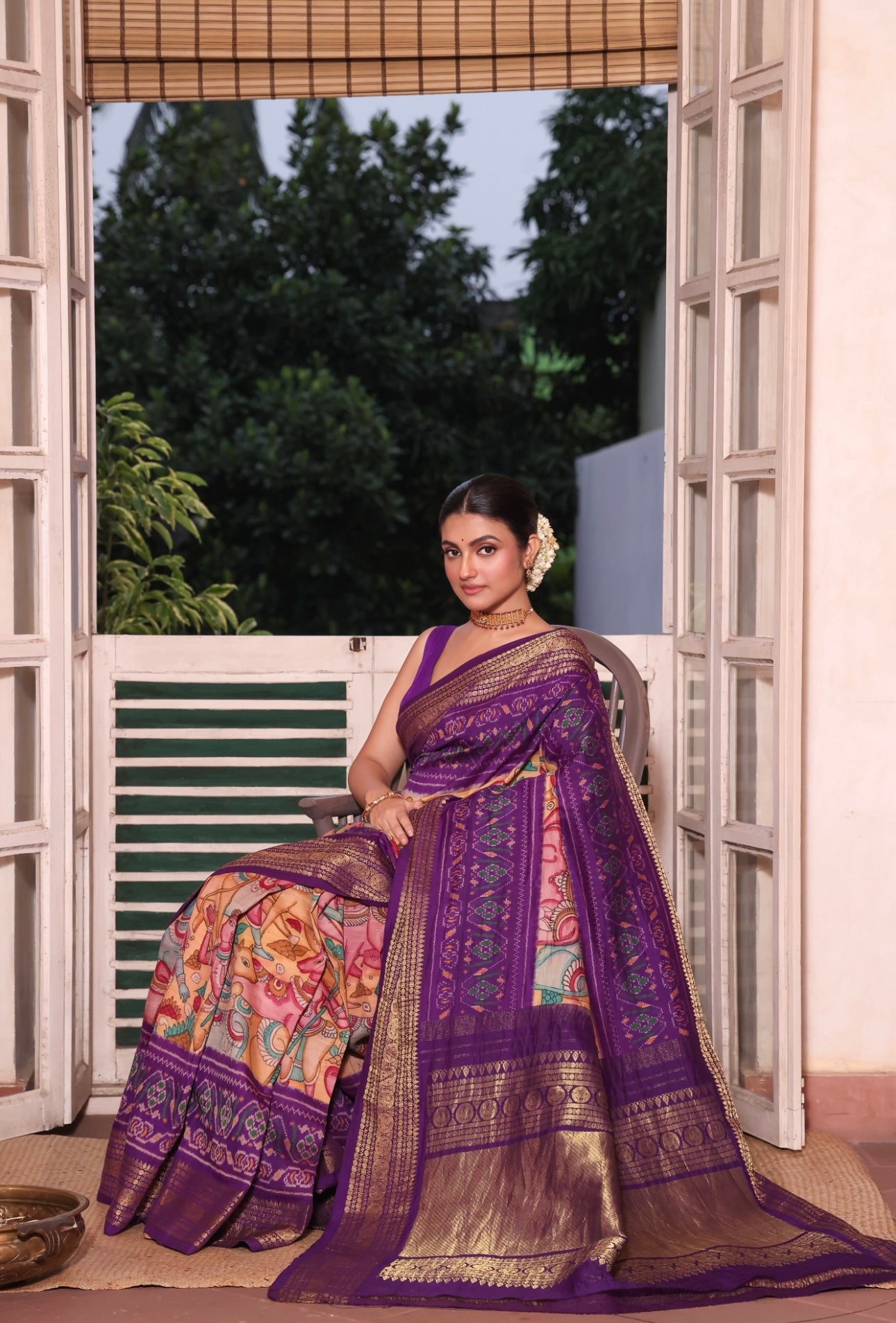 A gorgeous purple shade handwoven ikkat silk saree with kanchi jacquard border adorned with Handdrawn handpainted penkalamkari