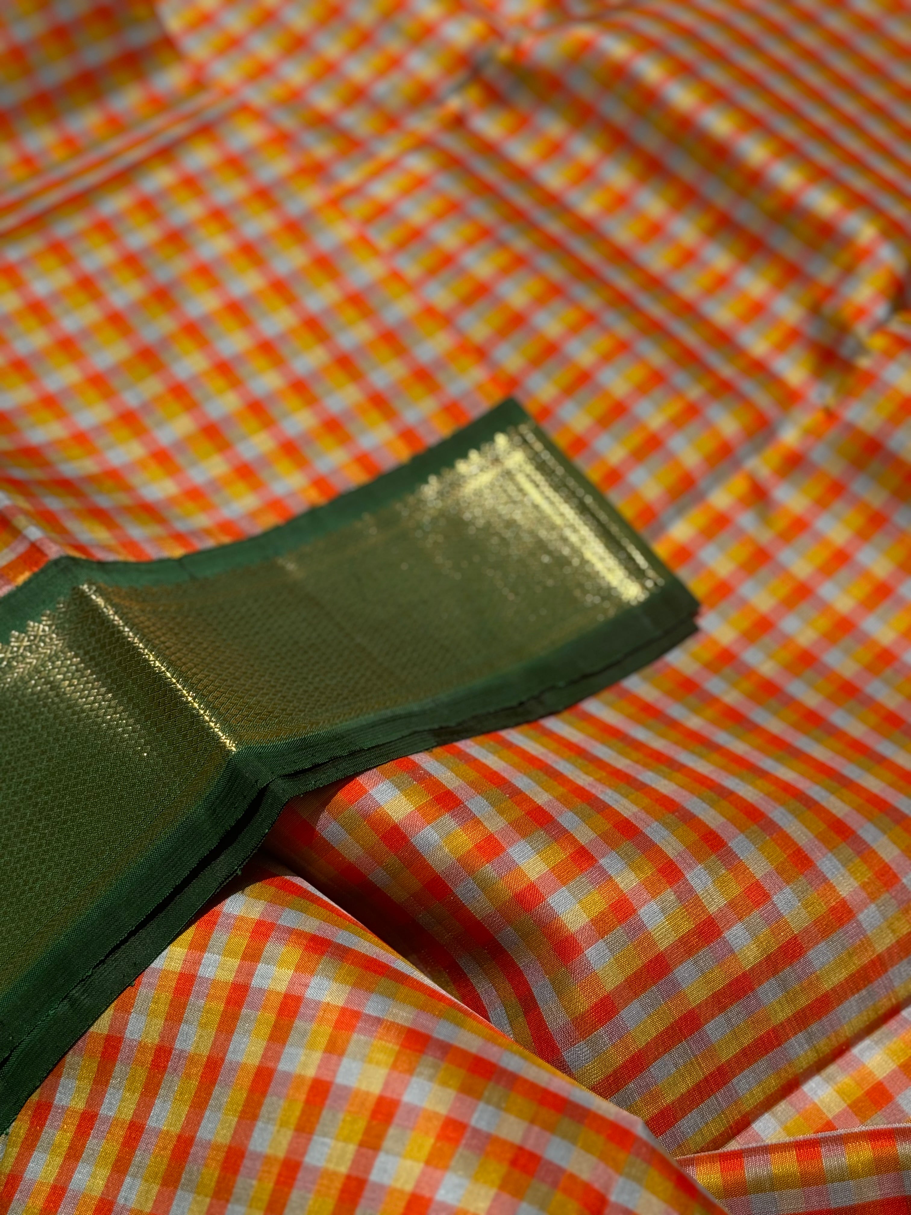 The stunner pastel orange and yellow checks with green shade korvai kanchivaram silk saree