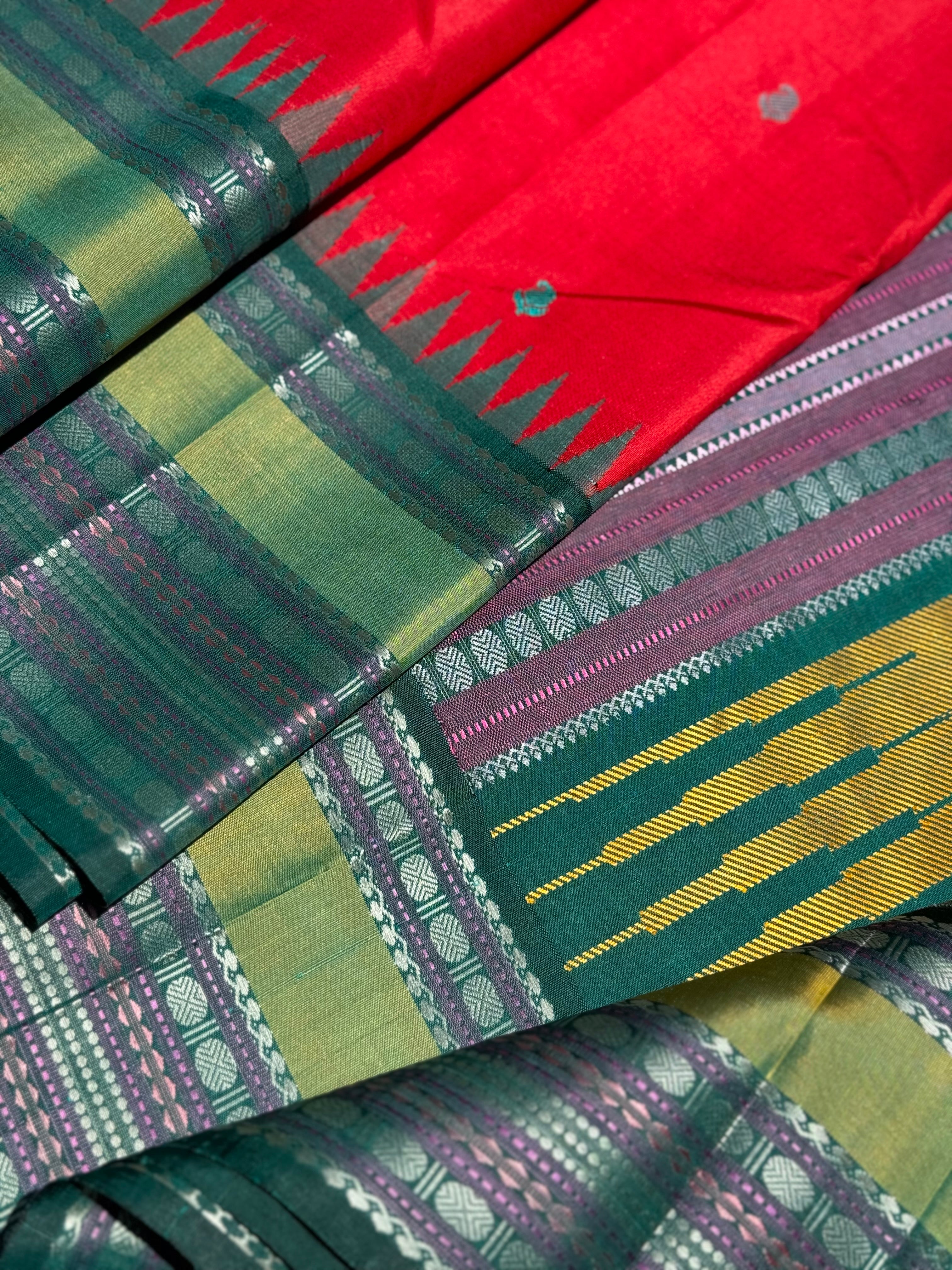 The stunner tomato red with green shade korvai kanchivaram silk saree with thread work korvai