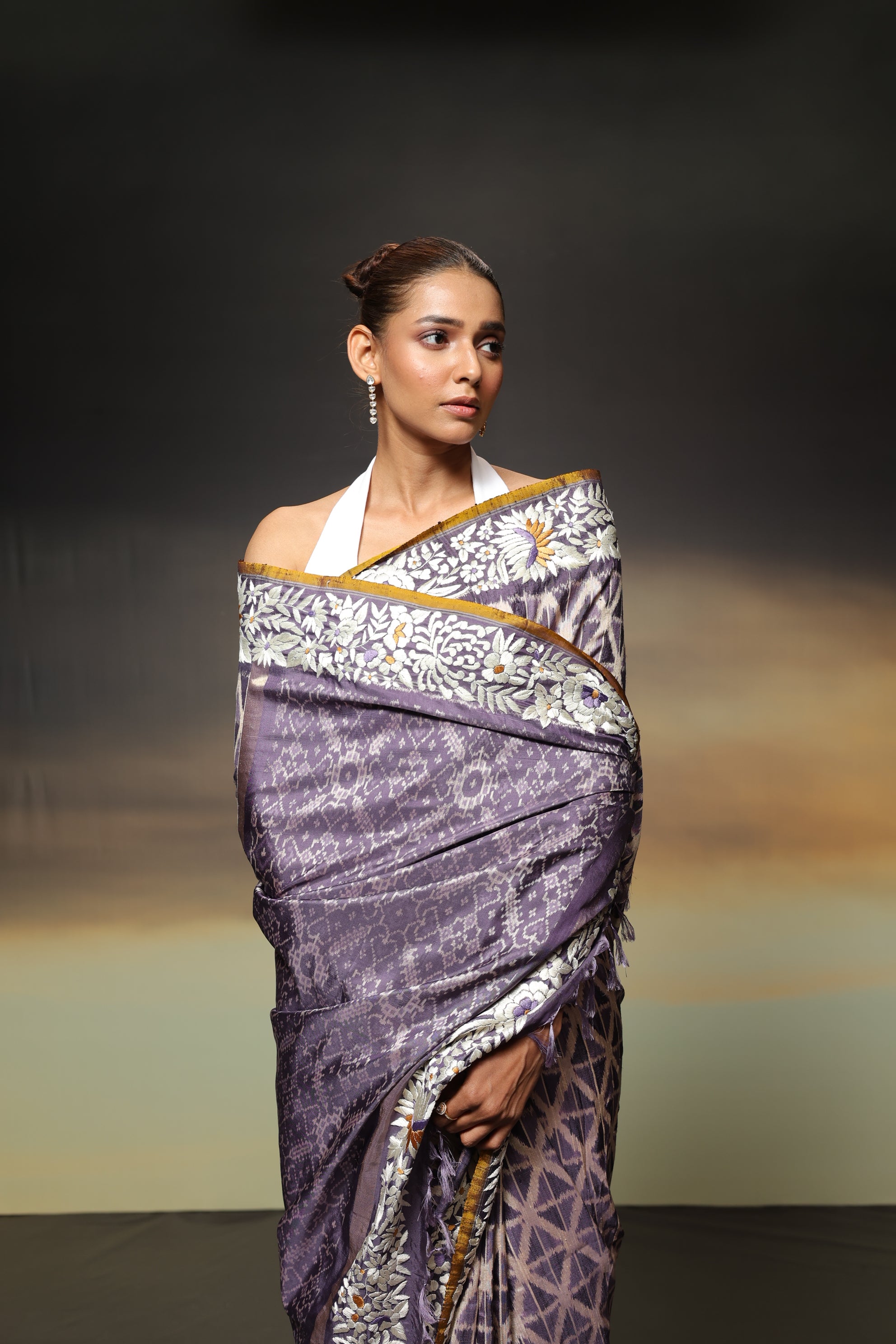 The stunning piece of art features tie-dyed ikkat in a captivating lavender shade with intricate Parsi Gara hand embroidery work