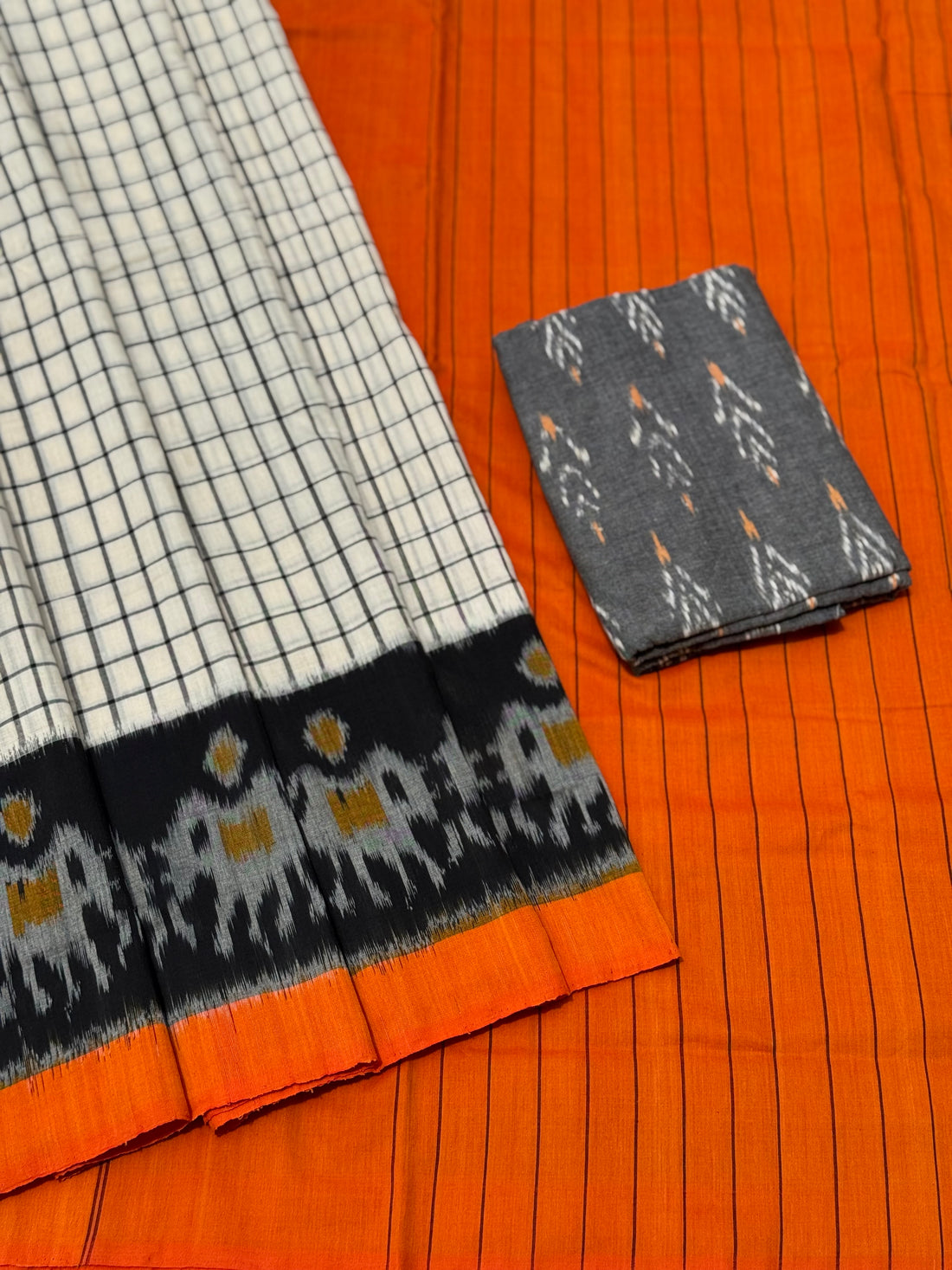 White checks with orange black handwoven weft single ikkat cotton saree