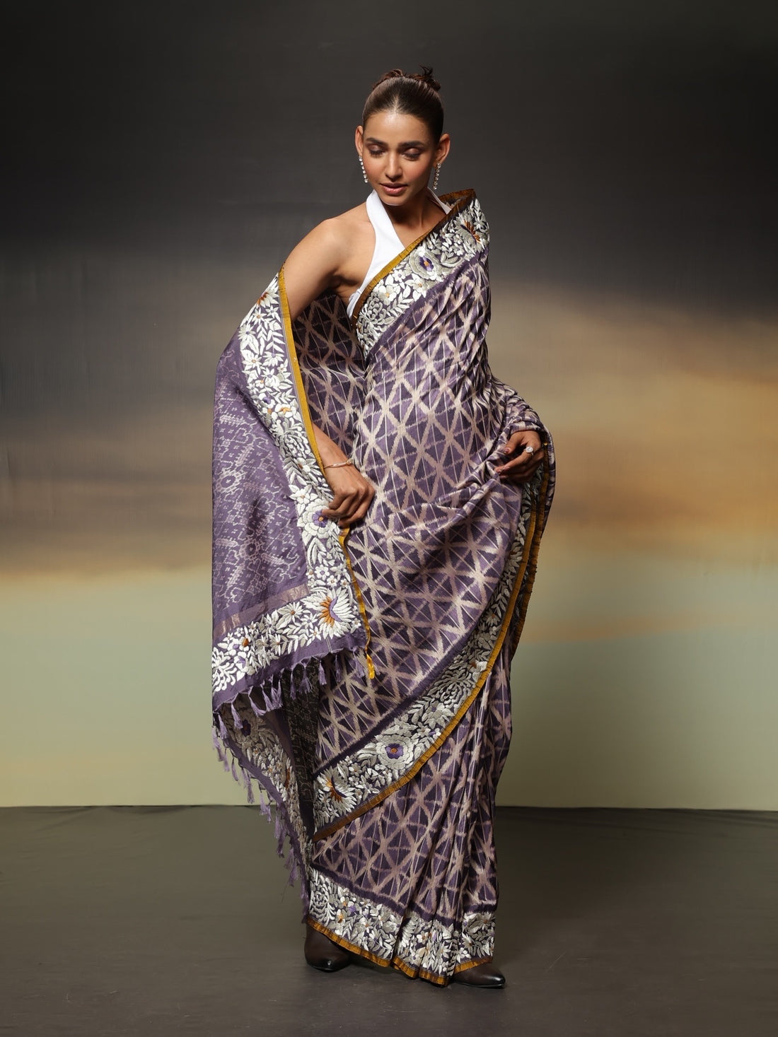 The stunning piece of art features tie-dyed ikkat in a captivating lavender shade with intricate Parsi Gara hand embroidery work