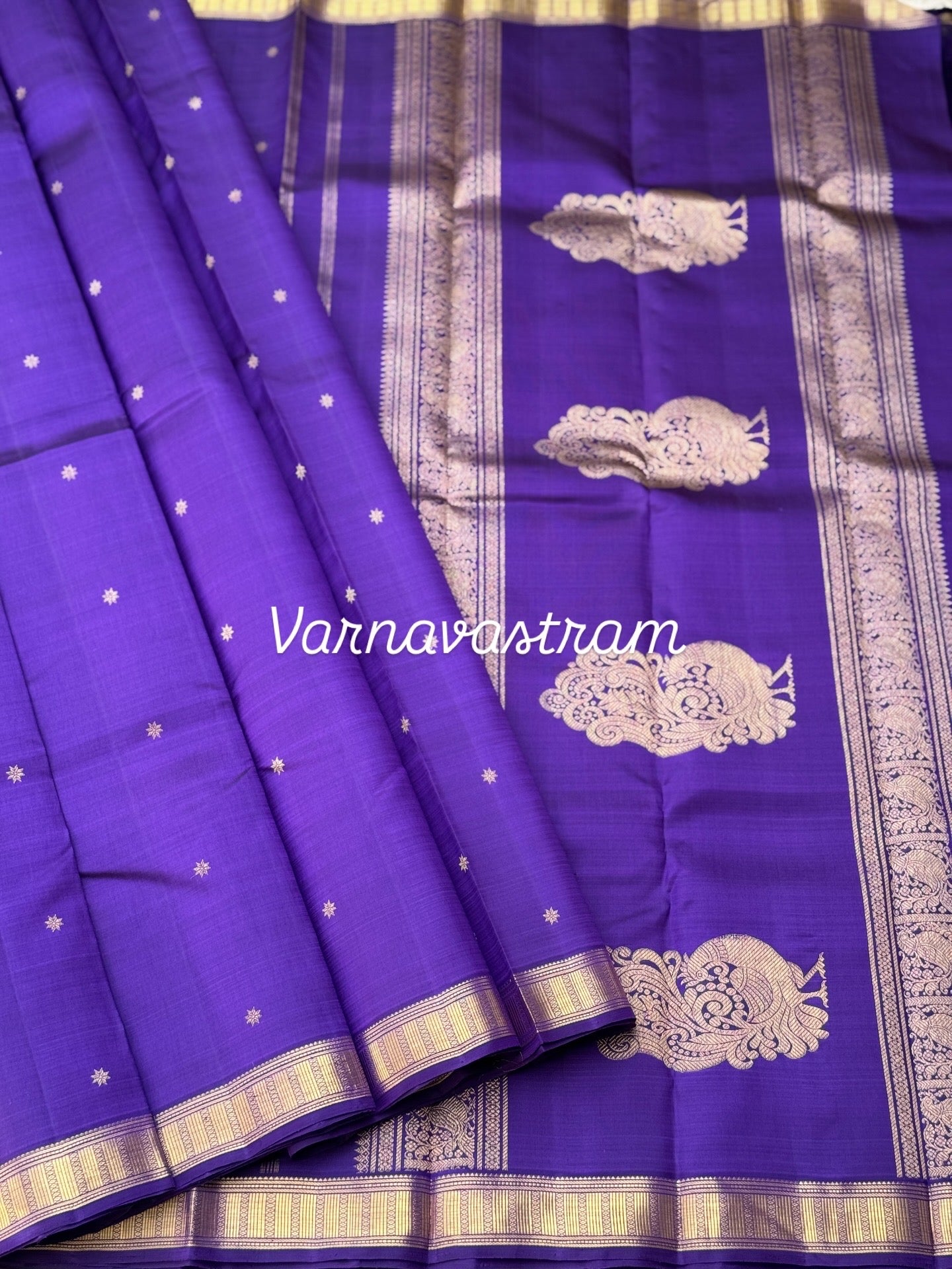 An elegant small border purple blue shade kanchivaram silk saree with star kamalam