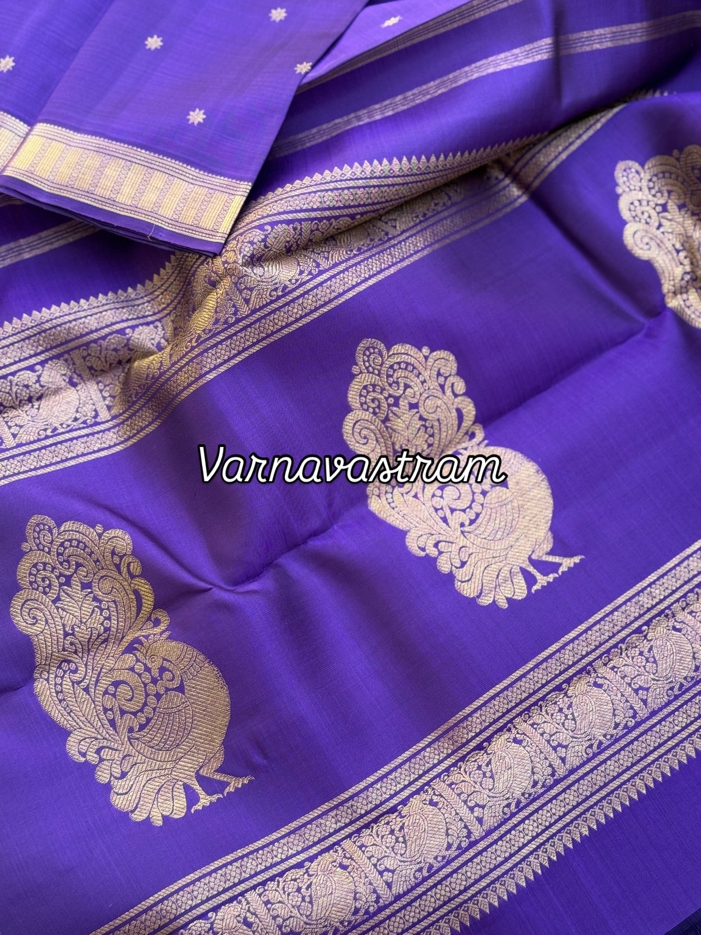 An elegant small border purple blue shade kanchivaram silk saree with star kamalam