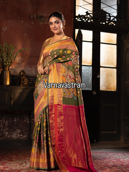 A beautiful and traditional korvai kanchivaram silk saree adorned with forest green base , dancing apsaras and floral creepers Handdrawn handpainted penkalamkari