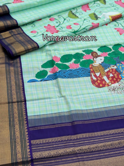 A stunner kanchivaram kattam korvai silk saree with foam green adorned with Handdrawn handpainted pichwai artwork