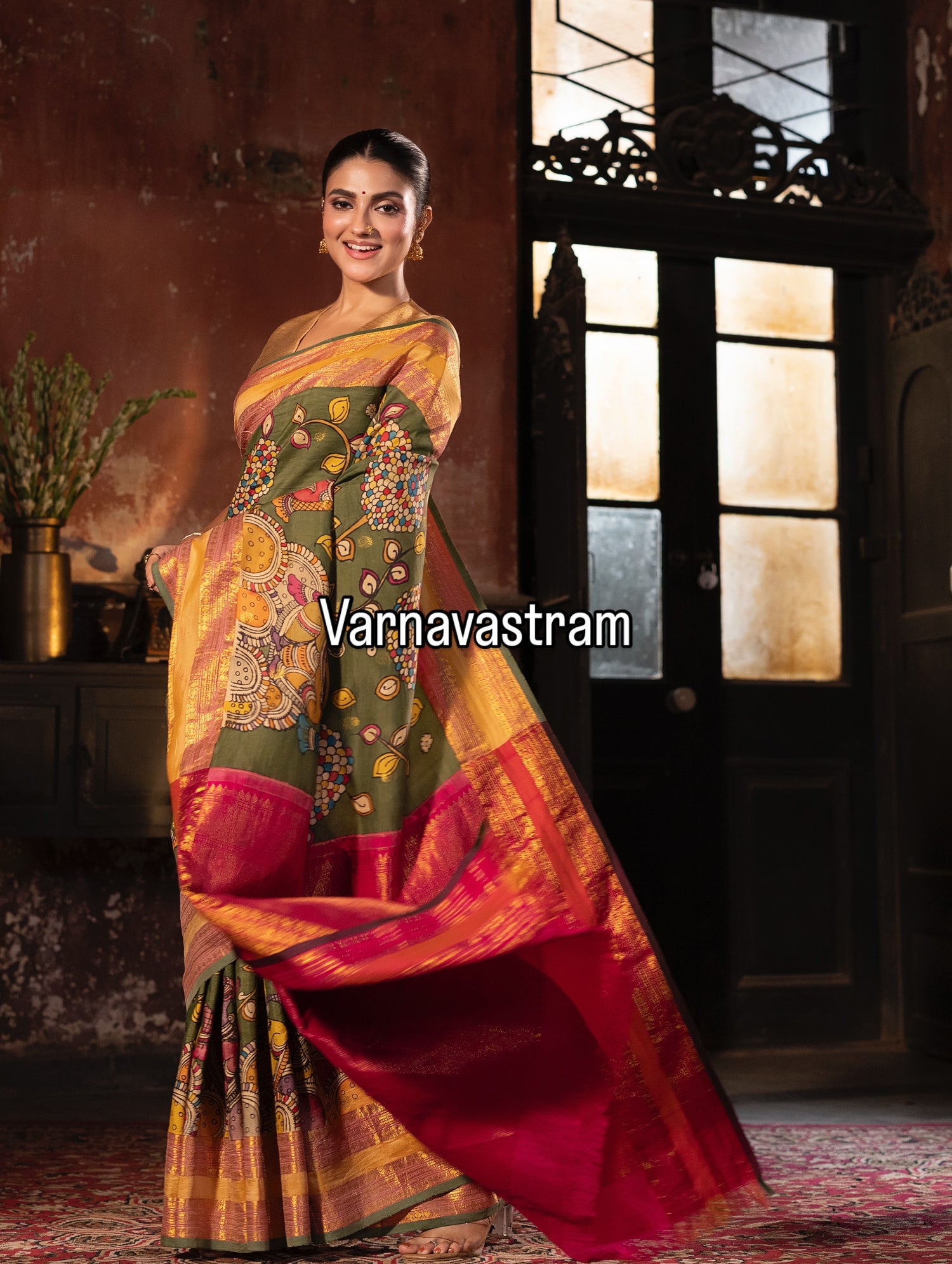 A beautiful and traditional korvai kanchivaram silk saree adorned with forest green base , dancing apsaras and floral creepers Handdrawn handpainted penkalamkari