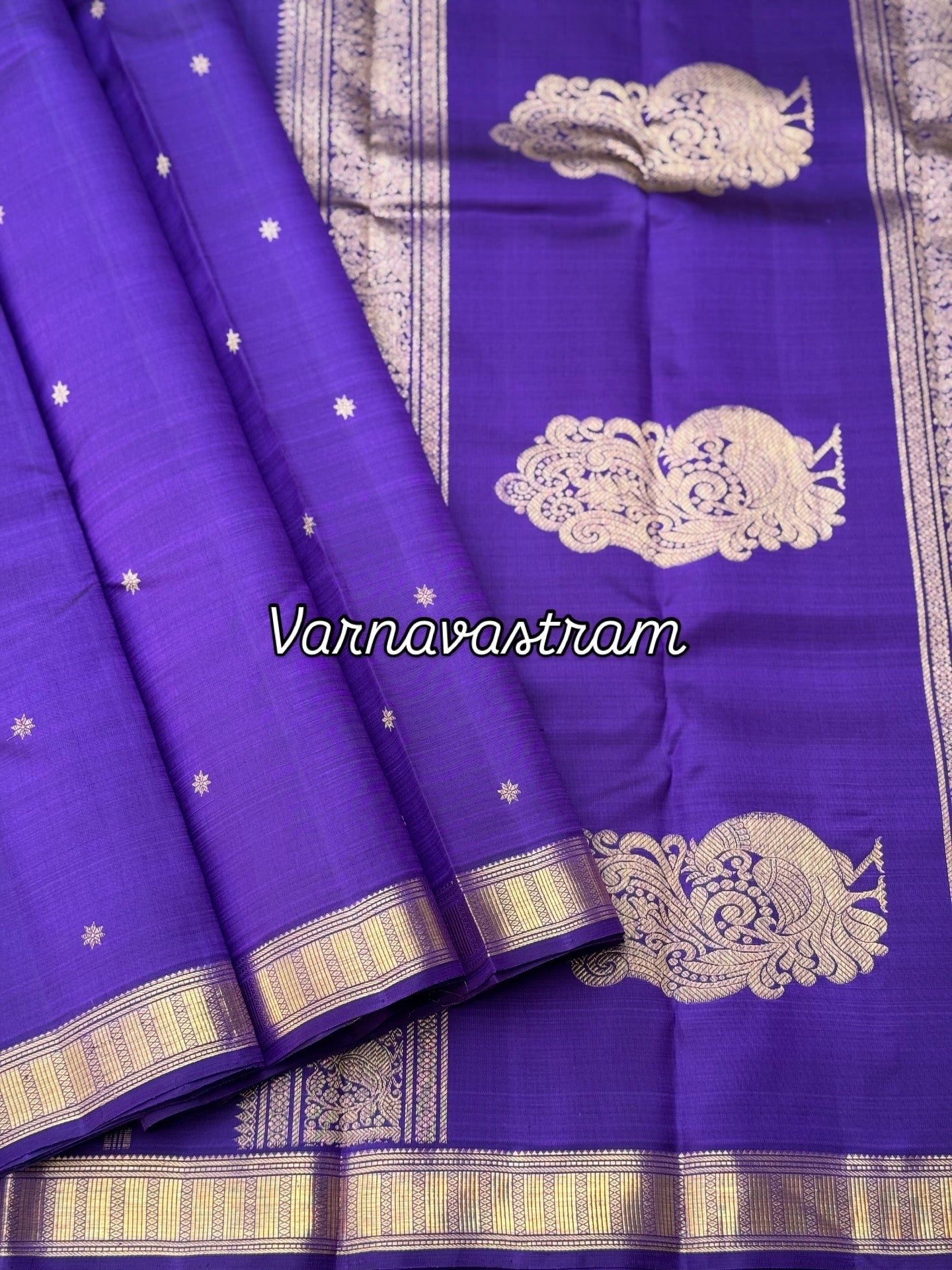 An elegant small border purple blue shade kanchivaram silk saree with star kamalam