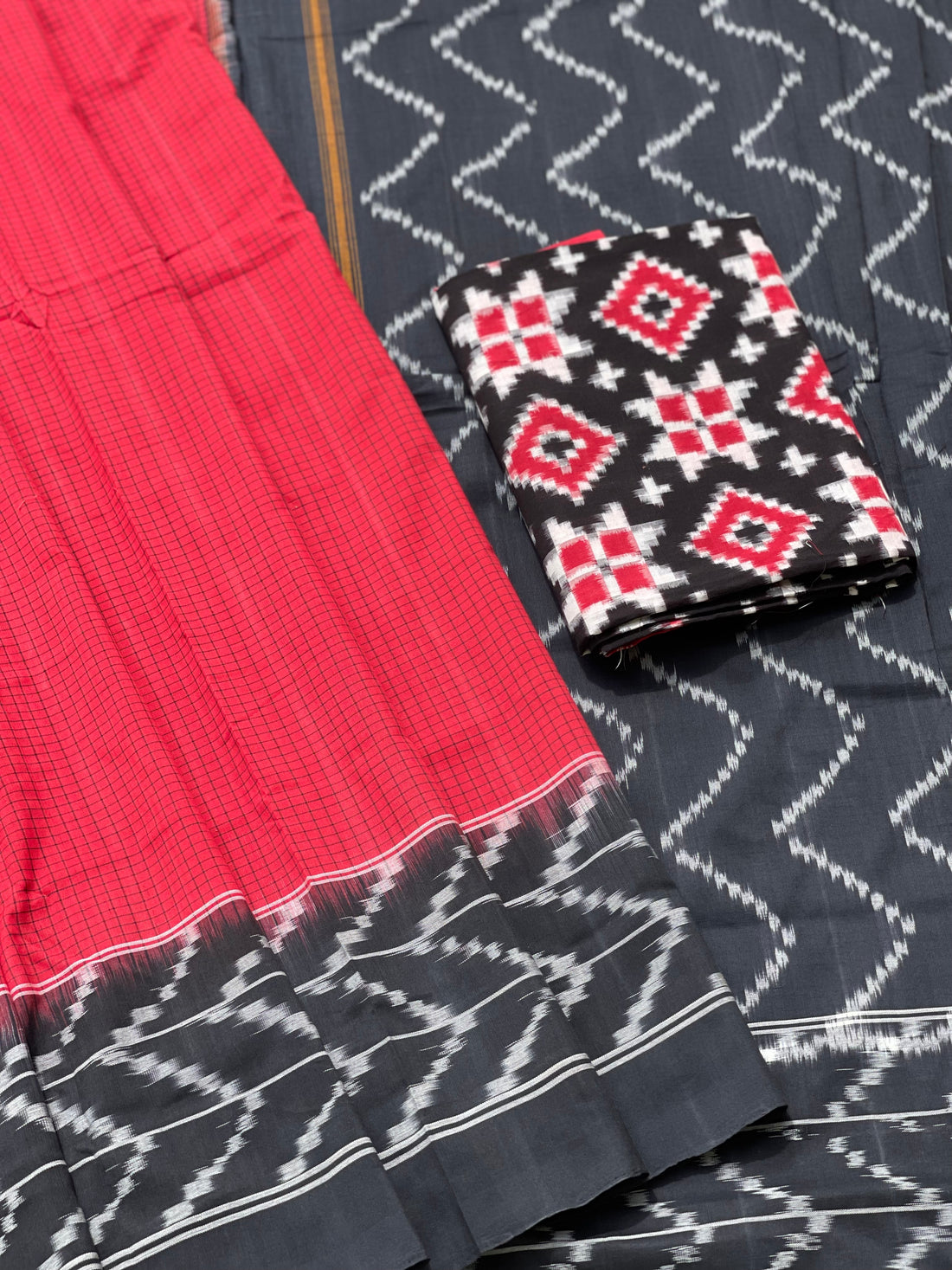 A Red checkered weft ikkat cotton Saree with chevron black border