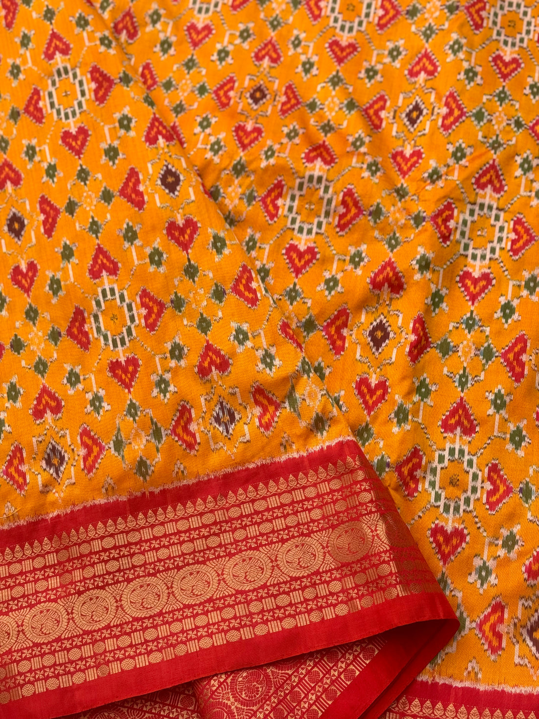 Yellowish orange with red kanchi jacquard weave zari border patola inspired navratan ikkat design on pure mulberry silk fabric