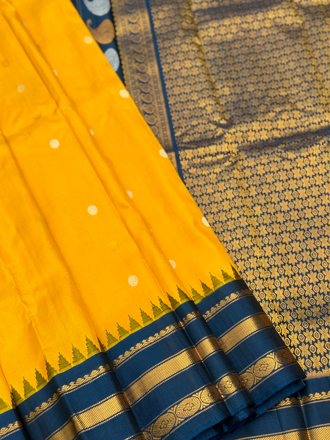 A gorgeous peacock blue with yellow handwoven gadwal silk saree