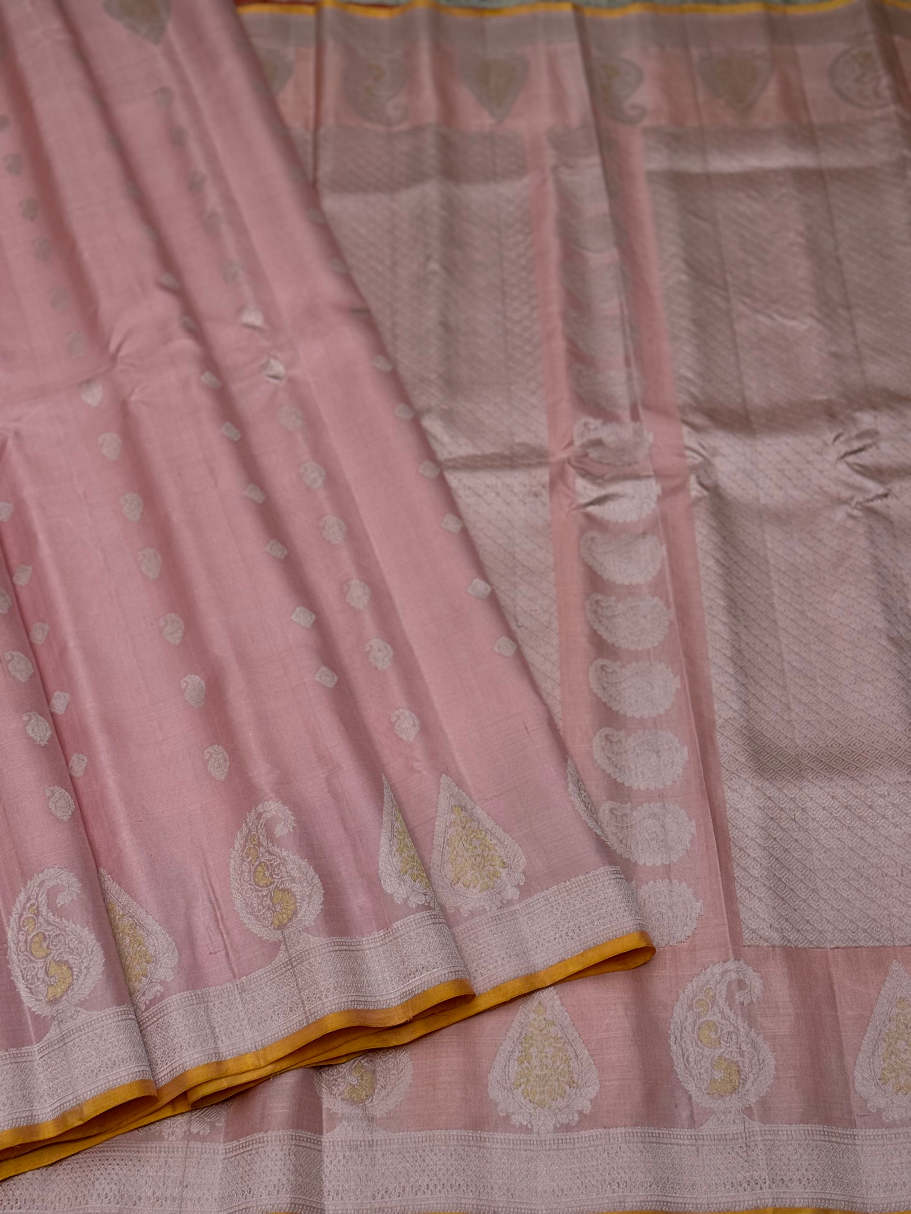 A gorgeous pastel baby pink with orange yellow handwoven gadwal silk saree