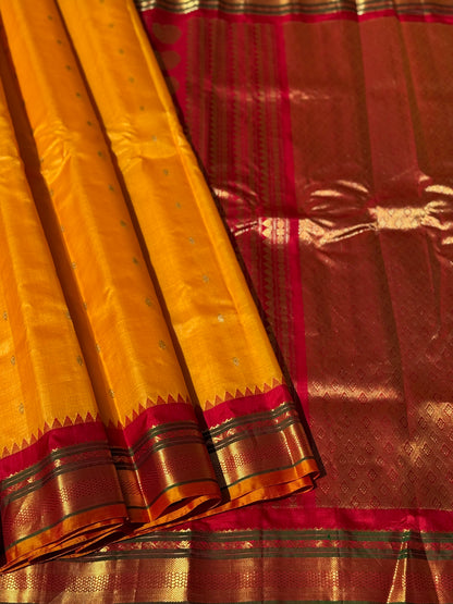 A gorgeous turmeric yellow with red temple border kuttu handwoven gadwal silk saree