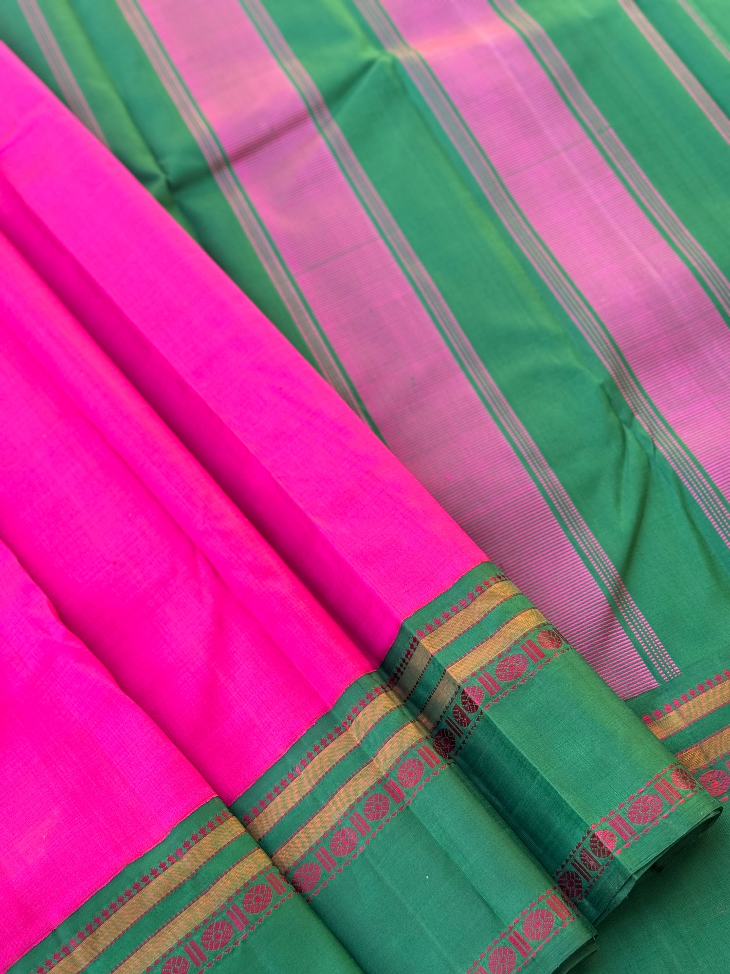 A subtle handwoven pattu rose pink shade with green Threadwork Kai korvai kanchivaram silk saree