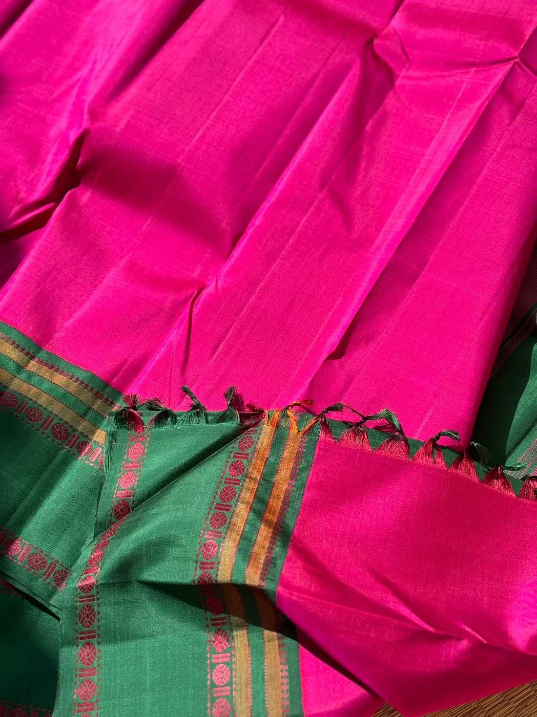 A subtle handwoven pattu rose pink shade with green Threadwork Kai korvai kanchivaram silk saree