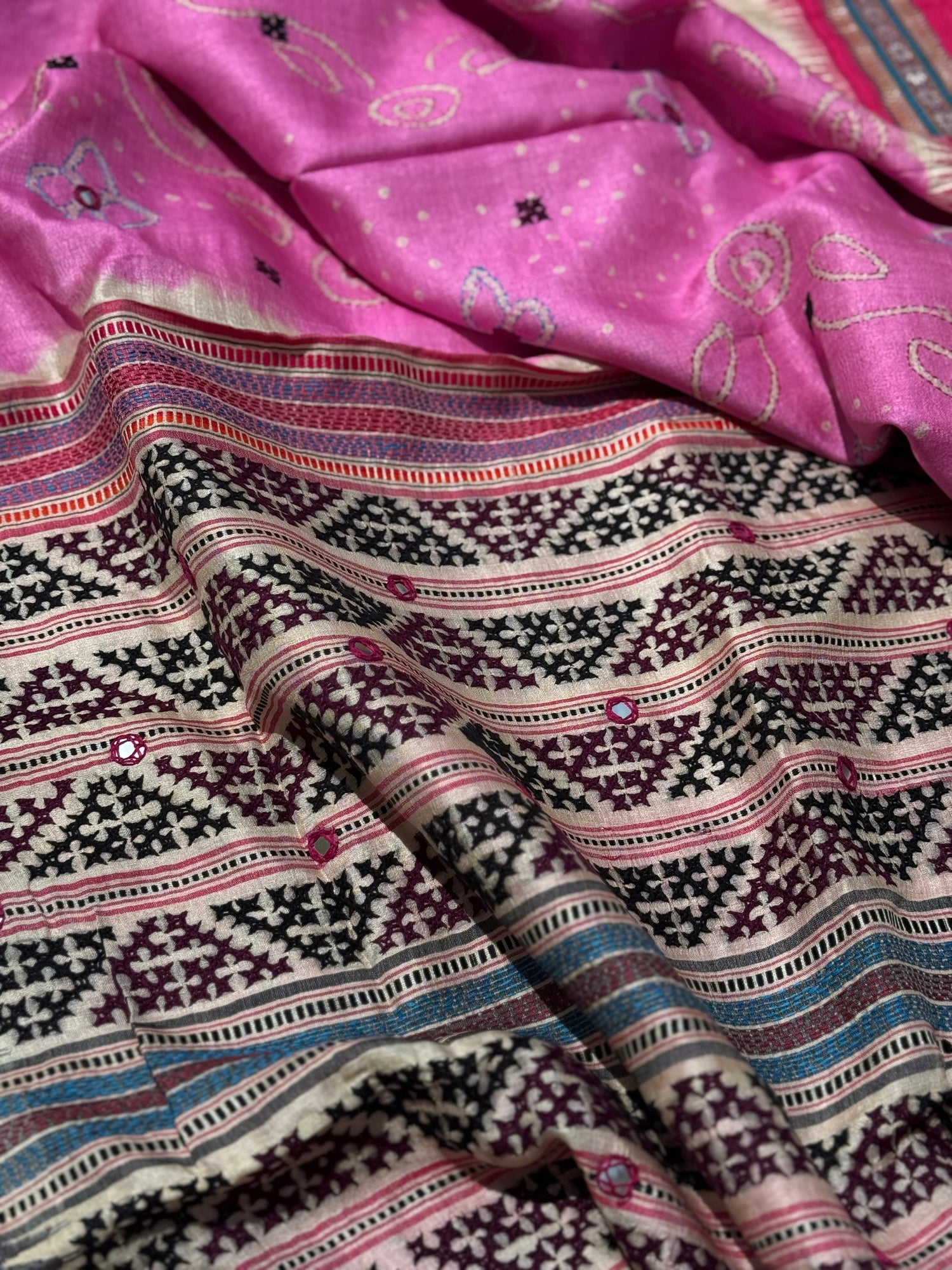 An exquisite handwoven vidharbha tussar silk saree with karvati kinar border intricately tie dyed with pink bhandhej and kutch hand embroidered