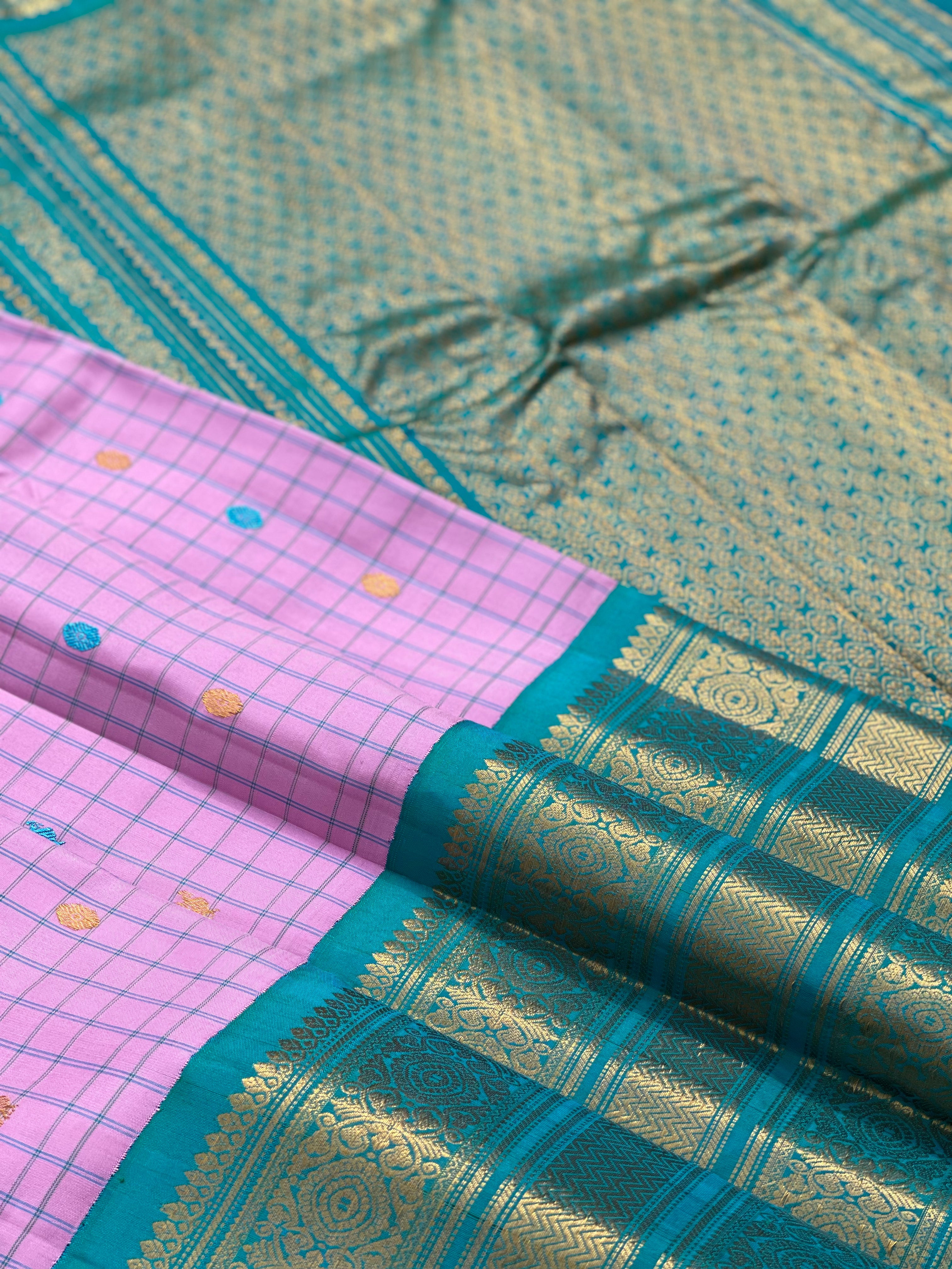 An Elegant baby pink Gadwal silk with Peacock green Kanchi turning border