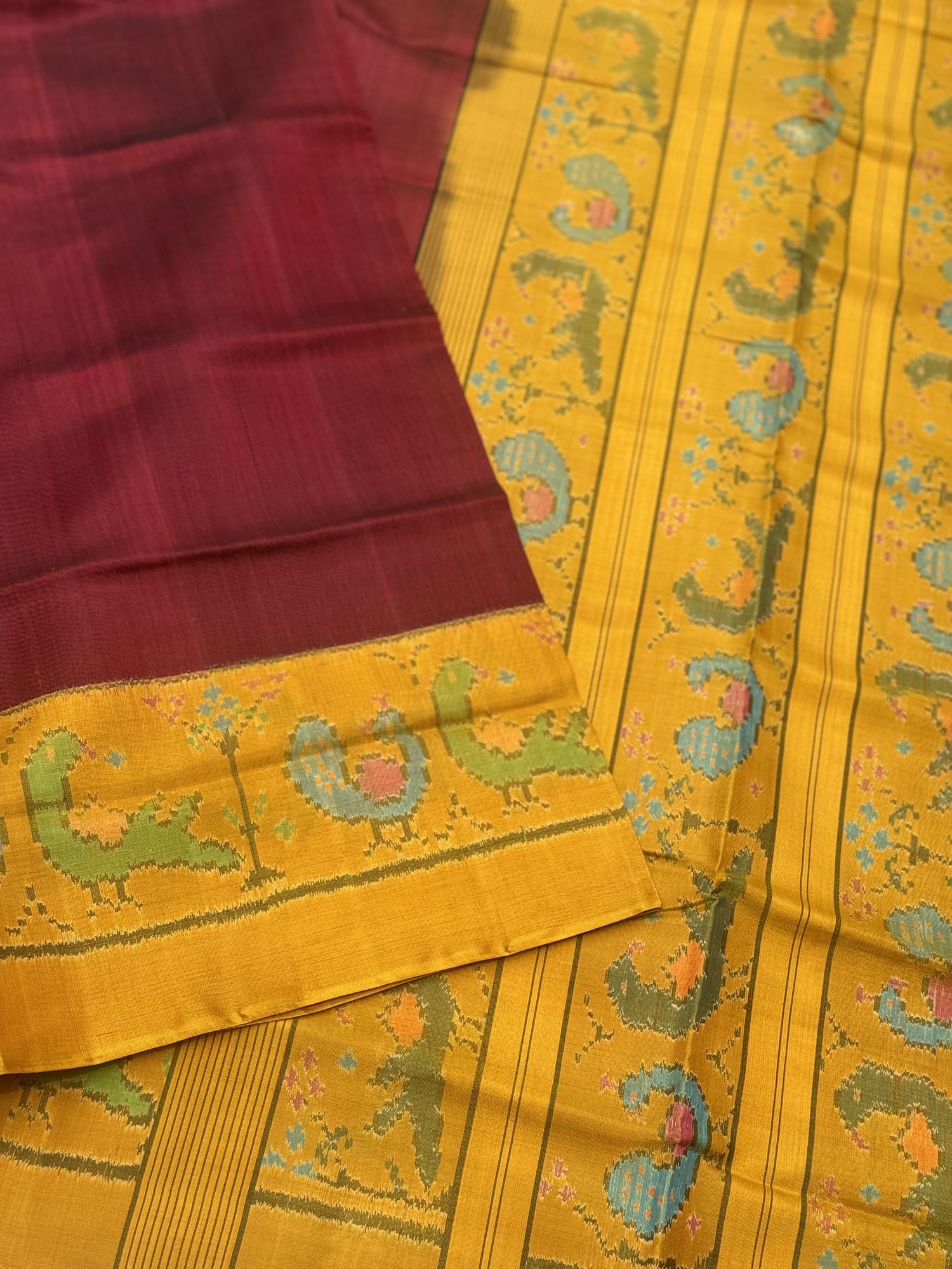 A gorgeous mustard yellow with burgundy single ikkat patola silk SAREE with parrot and peacock motifs