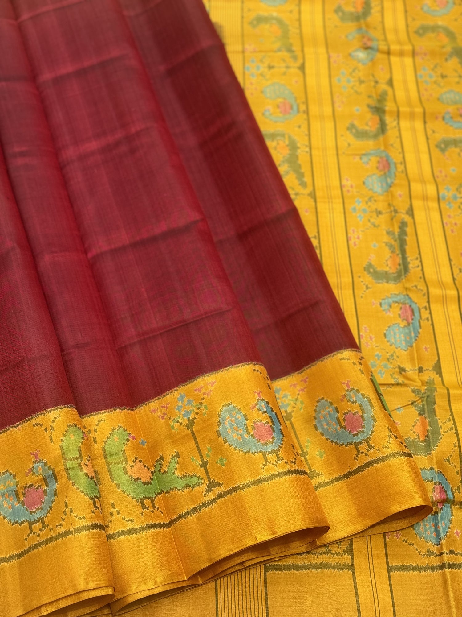 A gorgeous mustard yellow with burgundy single ikkat patola silk SAREE with parrot and peacock motifs