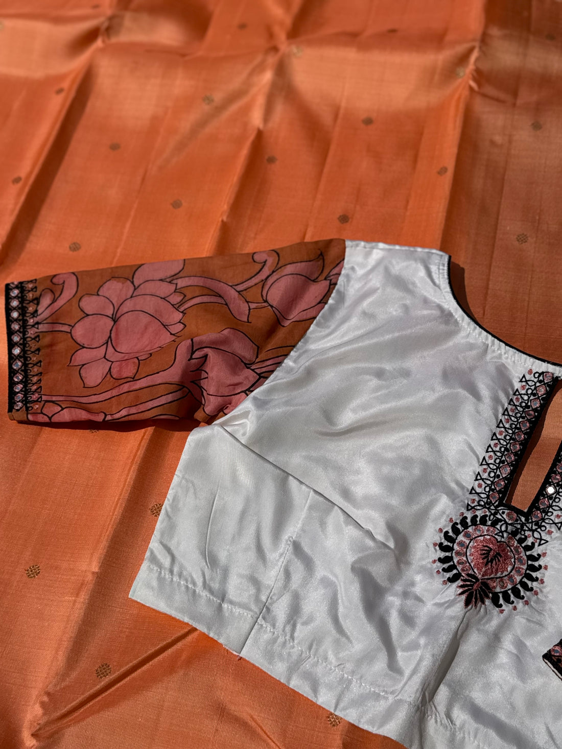 The contemporary style on peach orange with ivory white silk penkalamkari blouse