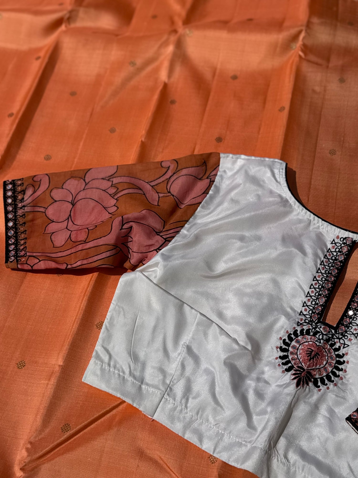The contemporary style on peach orange with ivory white silk penkalamkari blouse