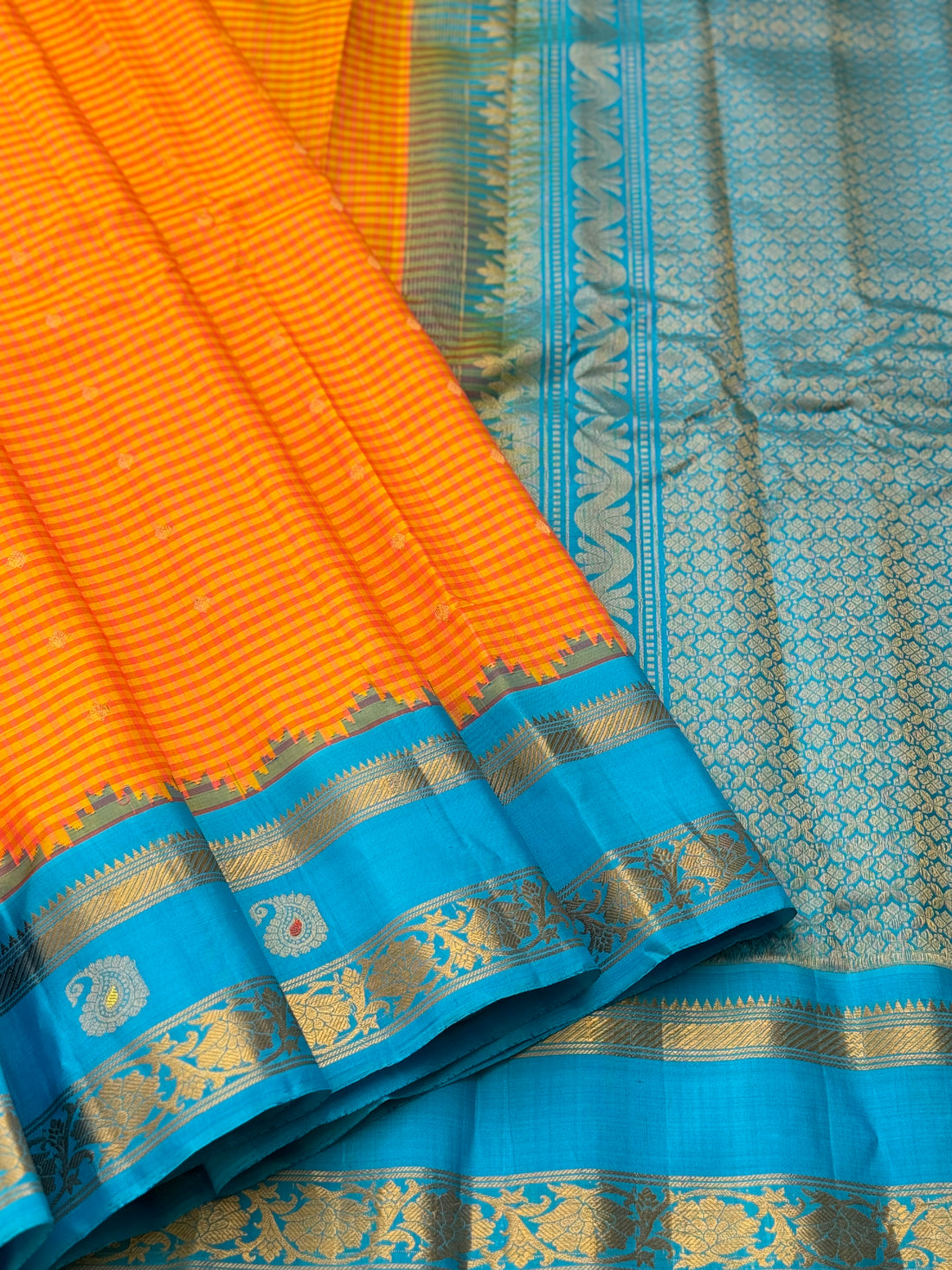 An Elegant sunset Orange with blue Gadwal silk saree with meenakari border