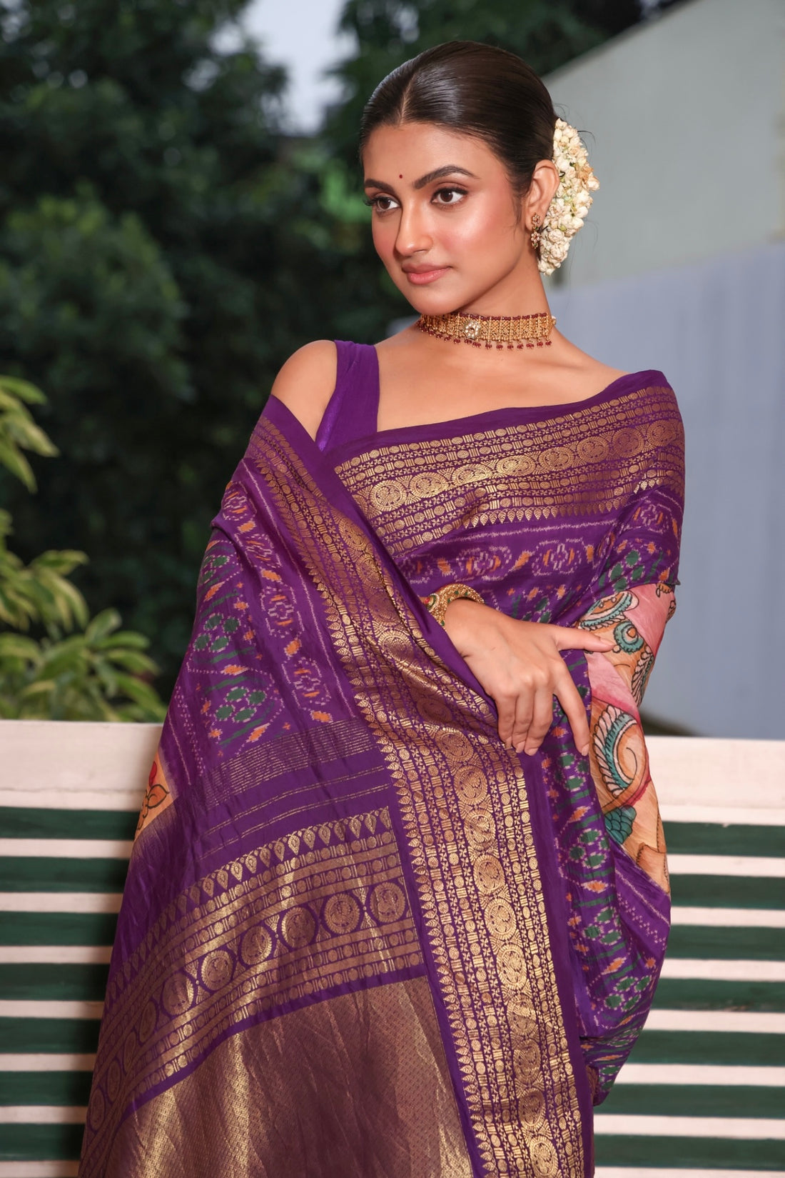 A gorgeous purple shade handwoven ikkat silk saree with kanchi jacquard border adorned with Handdrawn handpainted penkalamkari