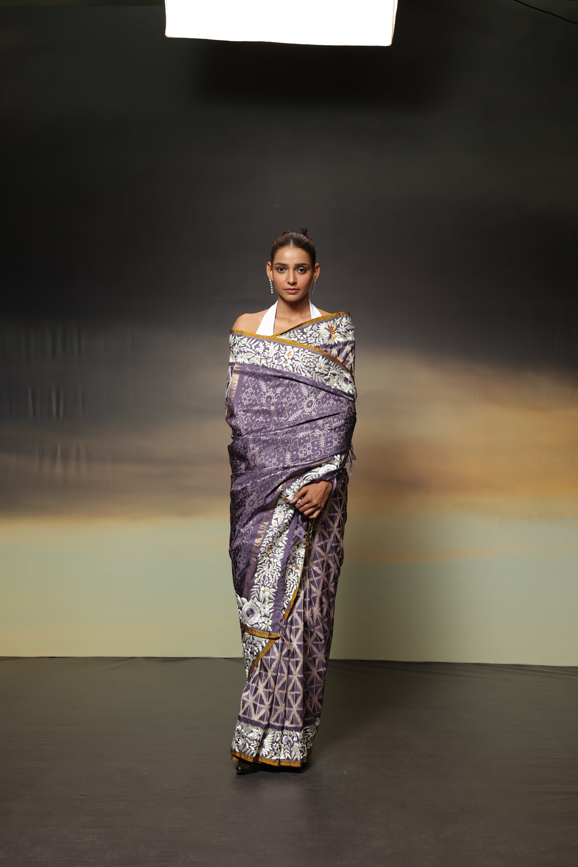 The stunning piece of art features tie-dyed ikkat in a captivating lavender shade with intricate Parsi Gara hand embroidery work