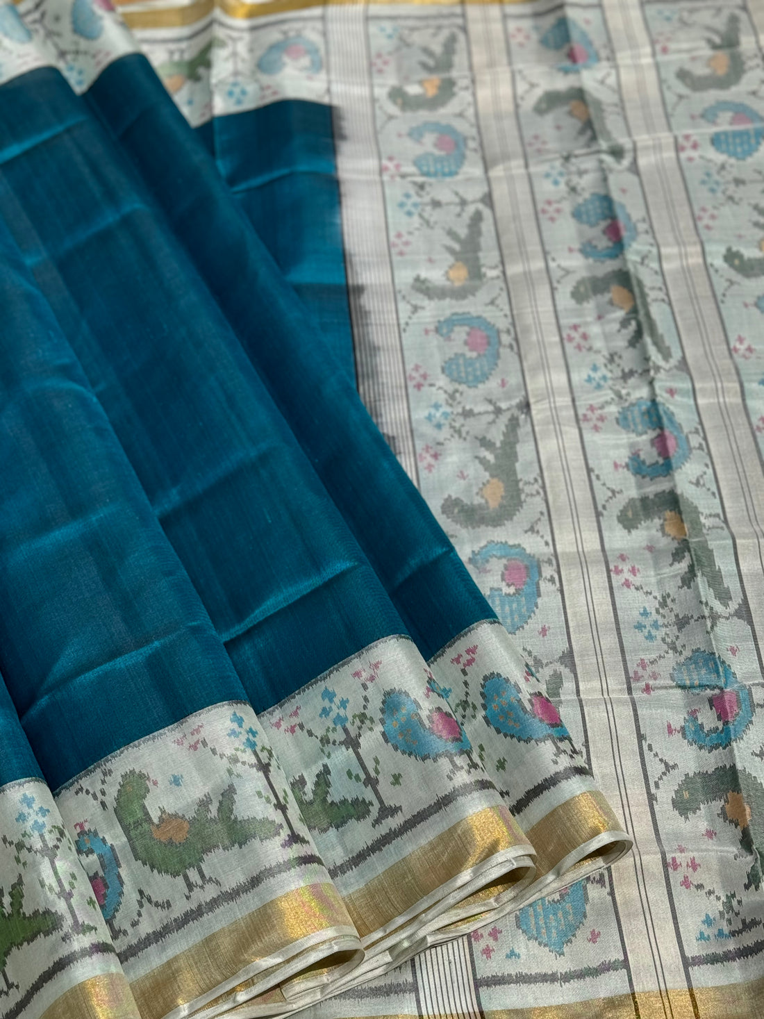 A gorgeous peacock blue with white single ikkat patola silk SAREE with parrot and peacock motifs