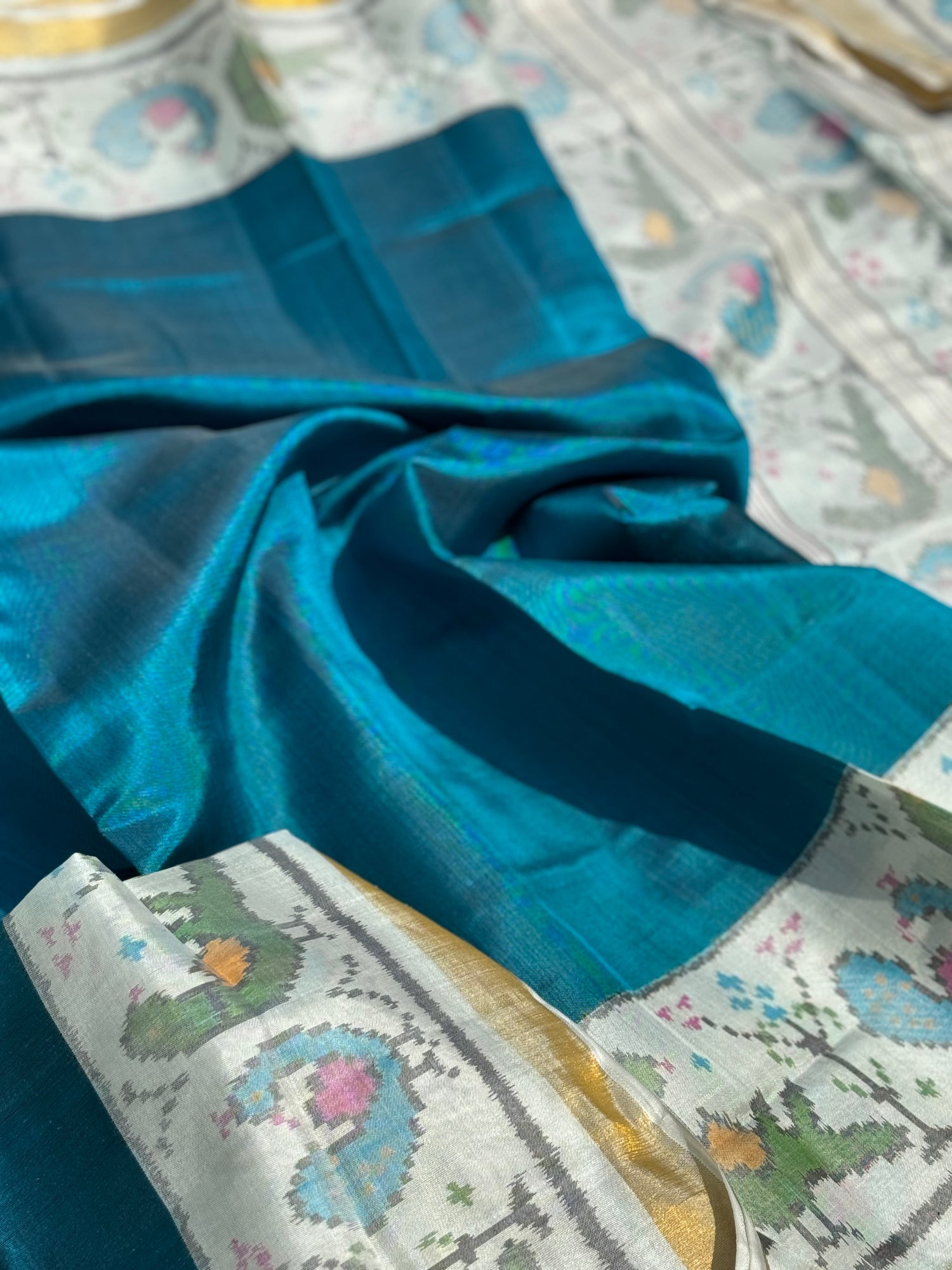 A gorgeous peacock blue with white single ikkat patola silk SAREE with parrot and peacock motifs