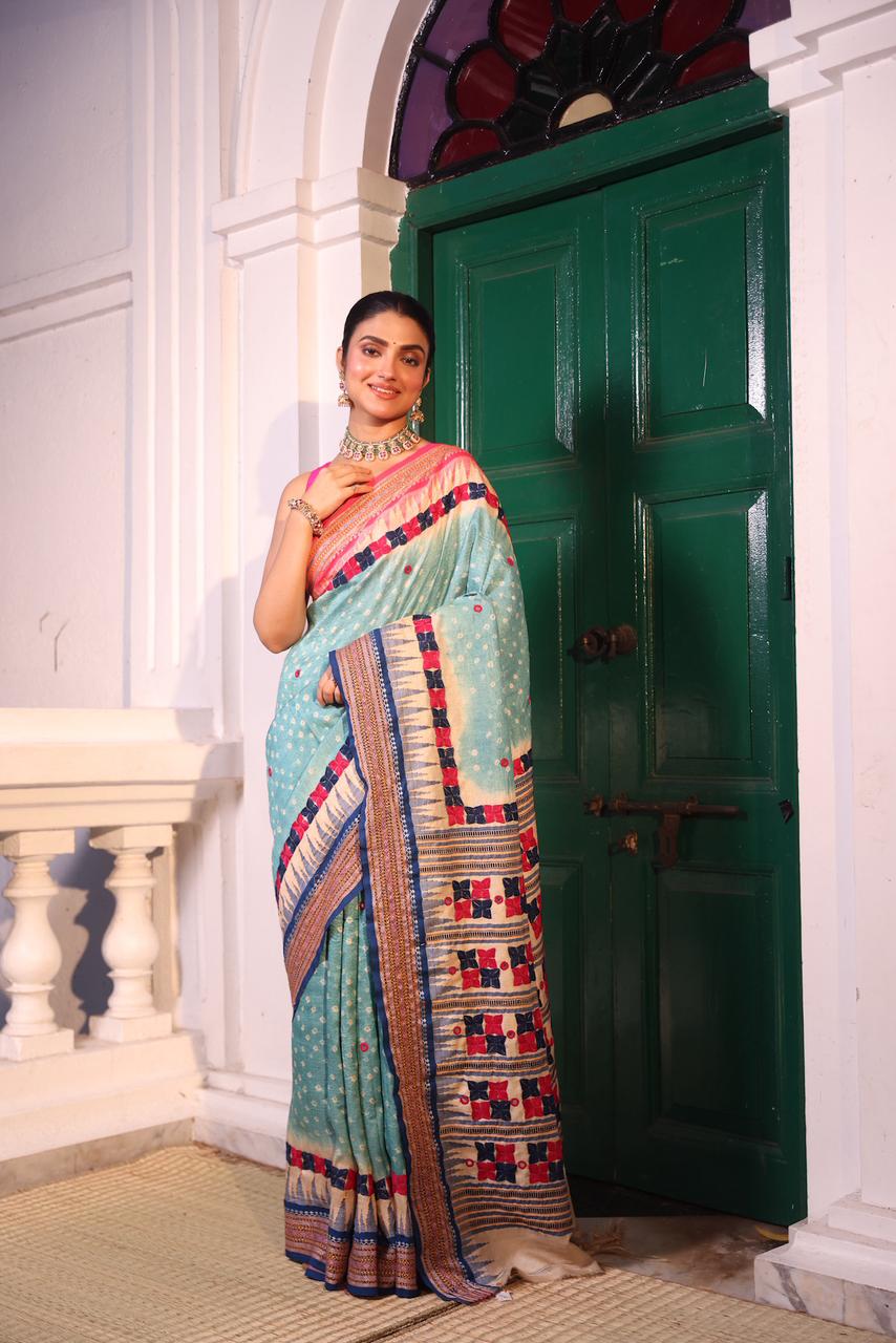 An exquisite handwoven vidharbha tussar silk saree with karvati kinar border intricately tie dyed with turquoise blue bhandhej and phulkari hand embroidered